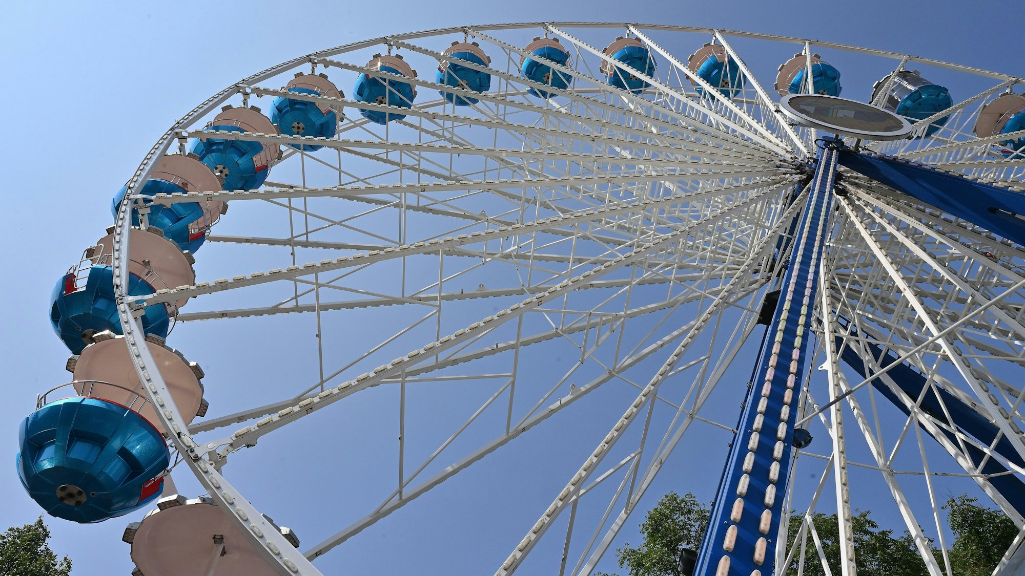 Ein Riesenrad vor blauem Himmel.