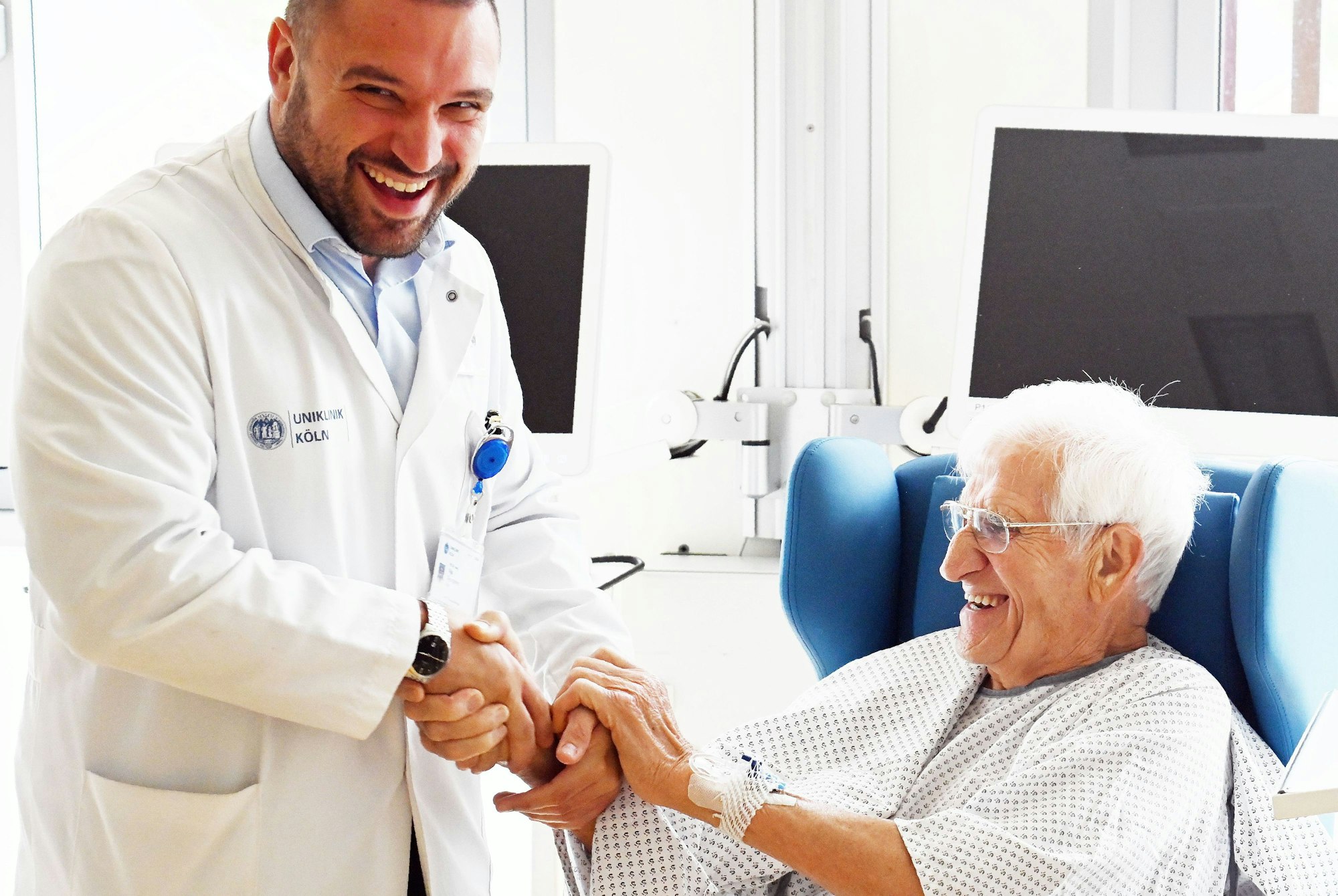 08.08.2025 Köln. Uniklinik Köln, Herzzentrum: Das Ehepaar Luise und Mathias Schinker , beide geboren 1938, hat sich gleichzeitig einen Aortenklappenersatz einsetzen lassen. Die behandelnden Ärzte Ilija Djordjevic (Vollbart) und Dr. Adam sind beim Interview auch dabei. Foto: Alexander Schwaiger