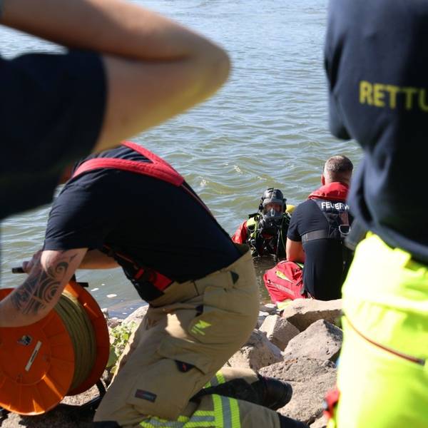 Ein Taucher und weitere Kräfte von Feuerwehr und Rettungsdienst sind am Rhein im Einsatz. Nach einer vermissten Person haben Rettungskräfte in Köln gesucht.