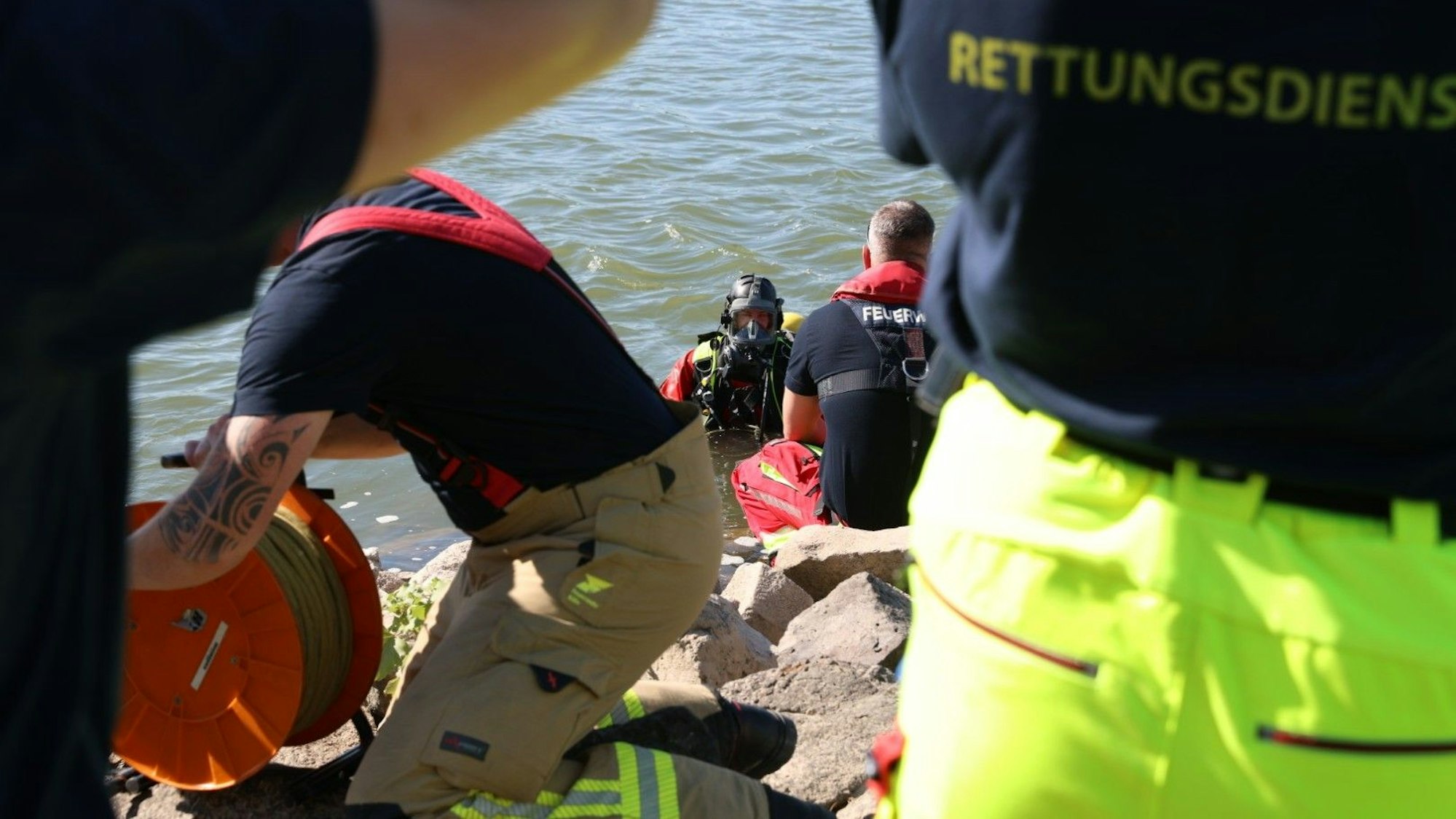 Ein Taucher und weitere Kräfte von Feuerwehr und Rettungsdienst sind am Rhein im Einsatz. Nach einer vermissten Person haben Rettungskräfte in Köln gesucht.