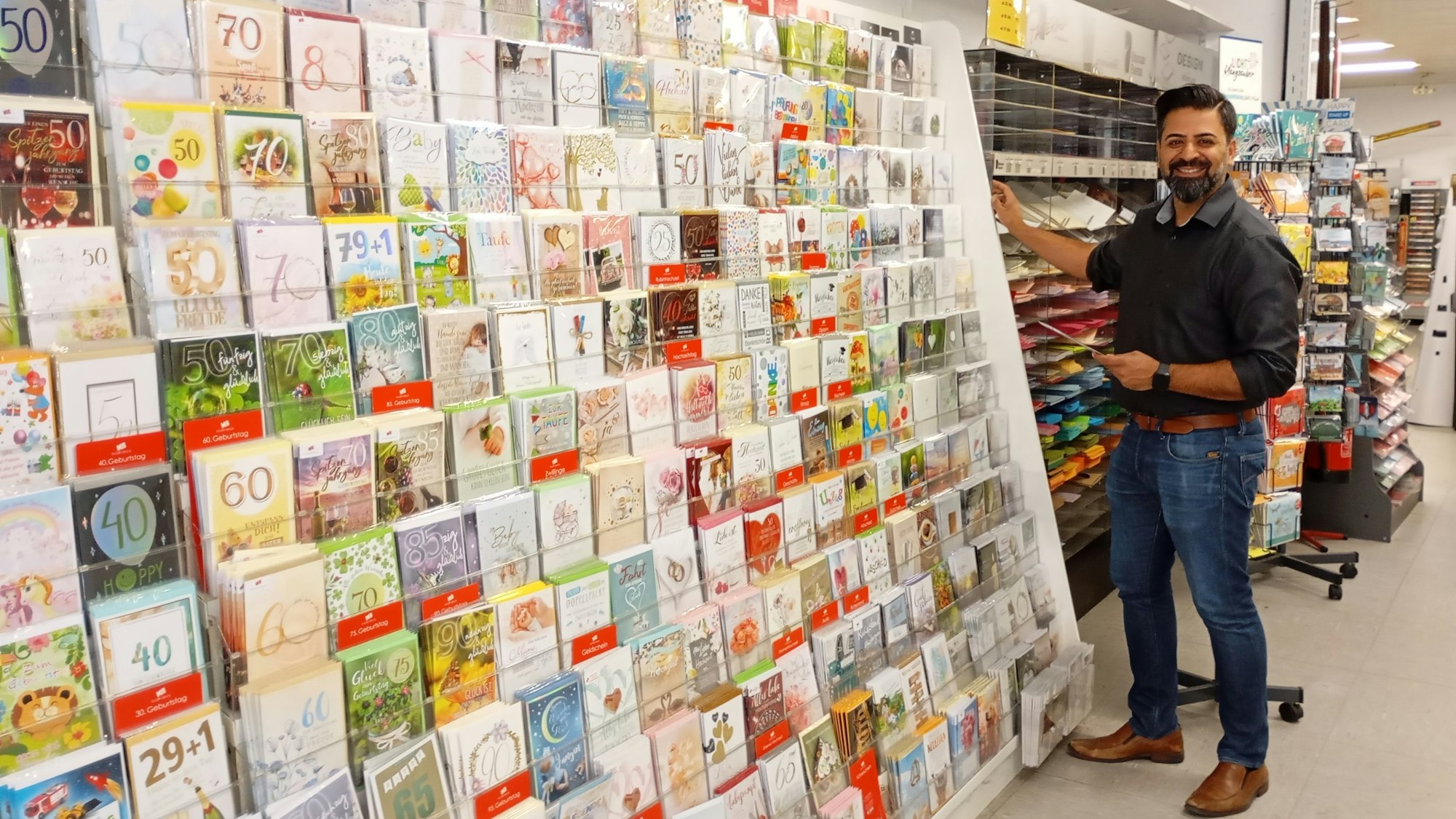 Das Foto zeigt einen Mann an einem Grußkartenstand.