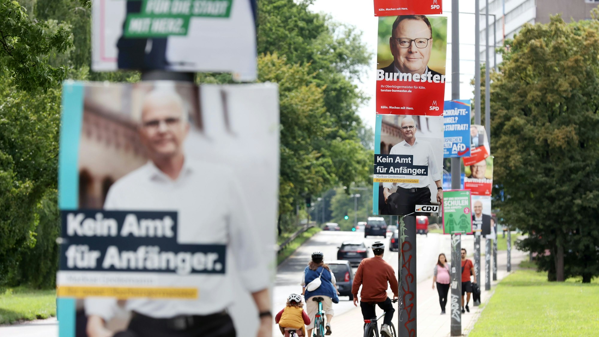 Wahlplakate zur Kommunalwahl in Köln hängen an einer Straße.