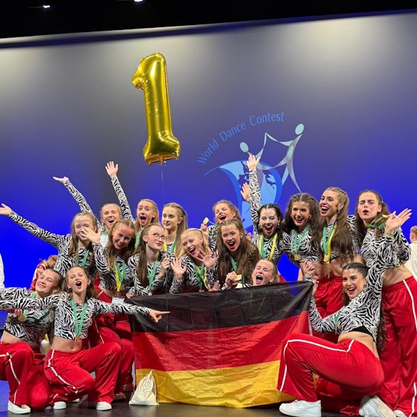 Das Foto zeigt die Tanzgruppe beim Jubeln mit einer Deutschlandfahne.
