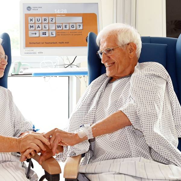 08.08.2025 Köln. Uniklinik Köln, Herzzentrum: Das Ehepaar Luise und Mathias Schinker , beide geboren 1938, hat sich gleichzeitig einen Aortenklappenersatz einsetzen lassen. Die behandelnden Ärzte Ilija Djordjevic (Vollbart) und Dr. Adam sind beim Interview auch dabei. Foto: Alexander Schwaiger
