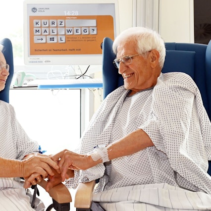 08.08.2025 Köln. Uniklinik Köln, Herzzentrum: Das Ehepaar Luise und Mathias Schinker , beide geboren 1938, hat sich gleichzeitig einen Aortenklappenersatz einsetzen lassen. Die behandelnden Ärzte Ilija Djordjevic (Vollbart) und Dr. Adam sind beim Interview auch dabei. Foto: Alexander Schwaiger