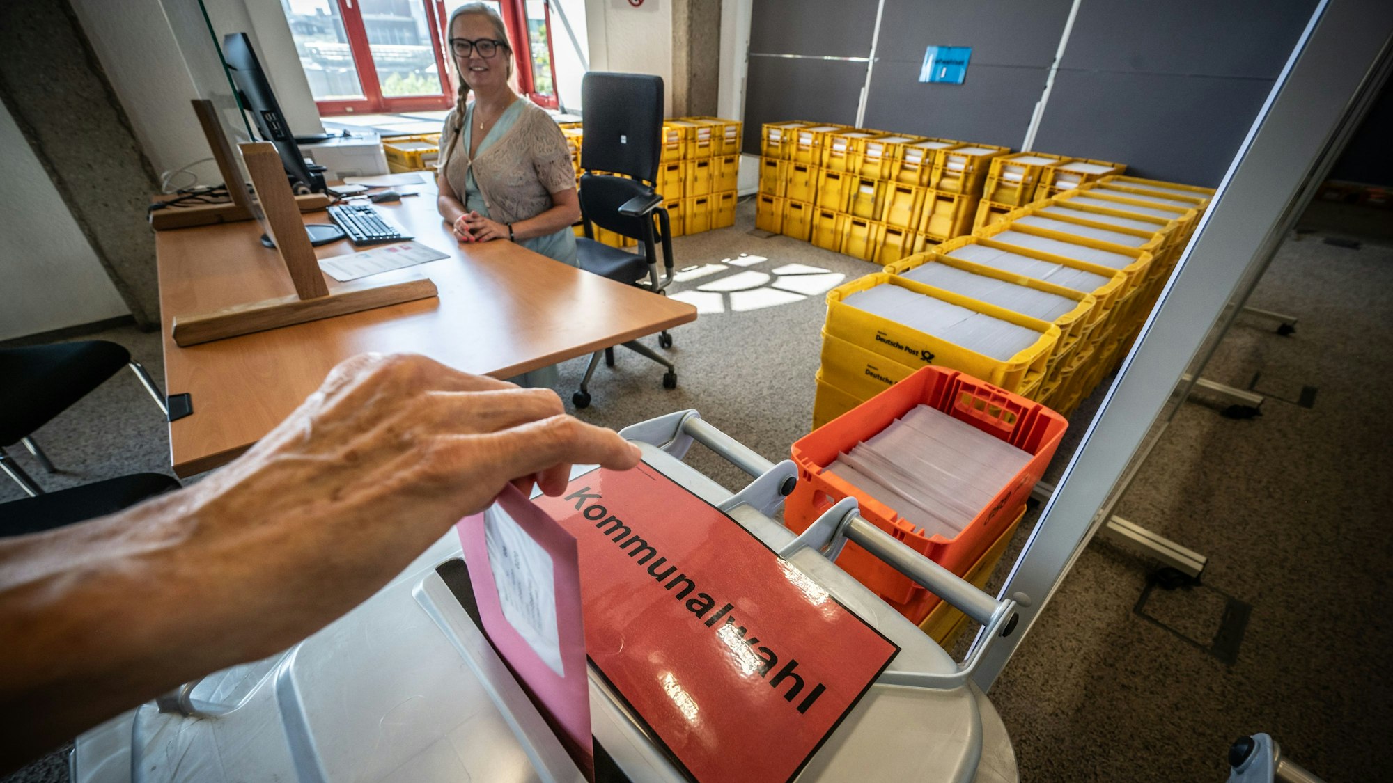 Stimmzettel zur Kommunalwahl. Hinterm Schalter sitzt Patrricia Danisch. Das Briefwahlbüro zur Kommunalwahl und zur Wahl des Intergrationsrats ist seit dem 11. august geöffnet. Bild: Ralf Krieger