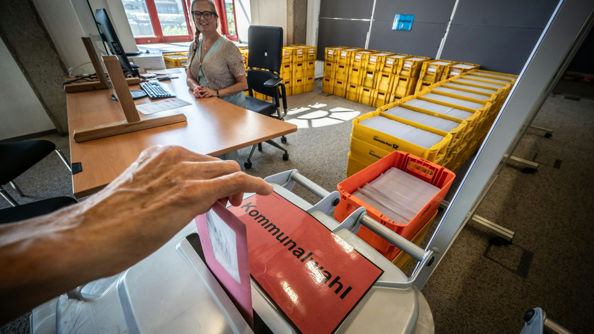 Stimmzettel zur Kommunalwahl. Hinterm Schalter sitzt Patrricia Danisch. Das Briefwahlbüro zur Kommunalwahl und zur Wahl des Intergrationsrats ist seit dem 11. august geöffnet. Bild: Ralf Krieger