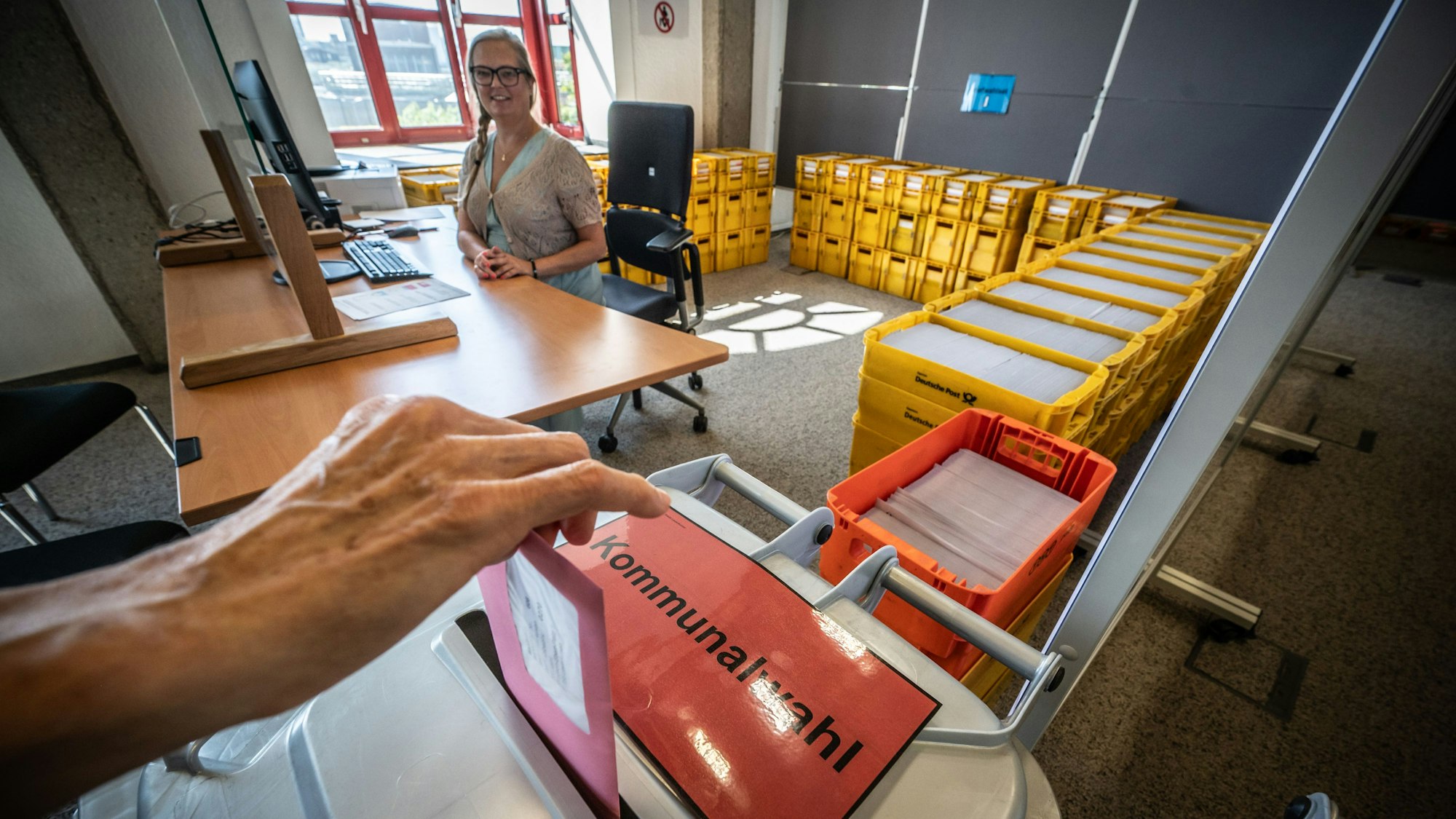 Stimmzettel zur Kommunalwahl. Hinterm Schalter sitzt Patrricia Danisch. Das Briefwahlbüro zur Kommunalwahl und zur Wahl des Intergrationsrats ist seit dem 11. August geöffnet. Bild: Ralf Krieger