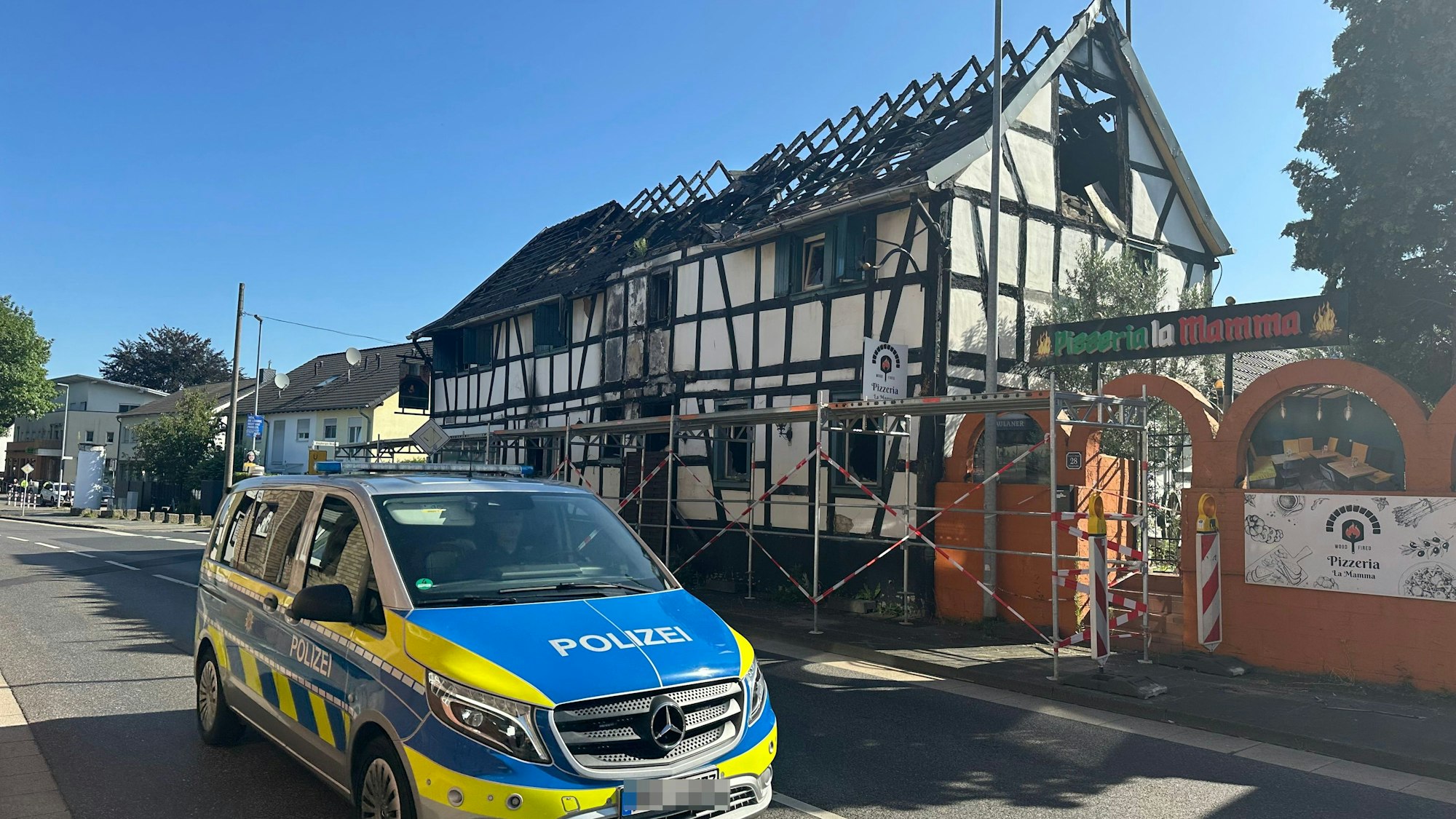 Ein Gerüst steht an der abgebrannten Pizzeria in Menden.