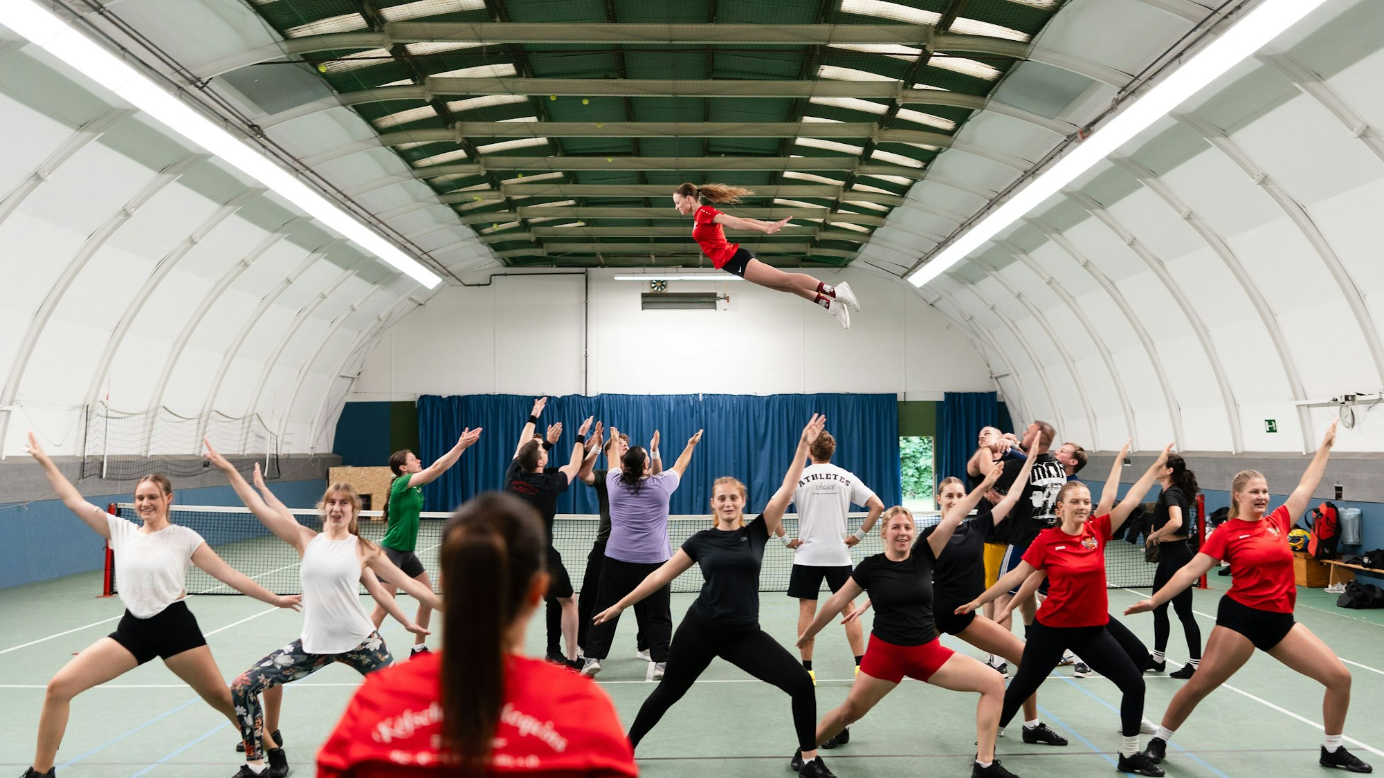 Eine Tänzerin der Tanzgruppe Kölsche Harlequins wird durch die Luft geworfen.