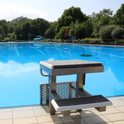 Ein mit Wasser gefülltes 50-Meter-Becken, im Vordergrund ein Startblock.