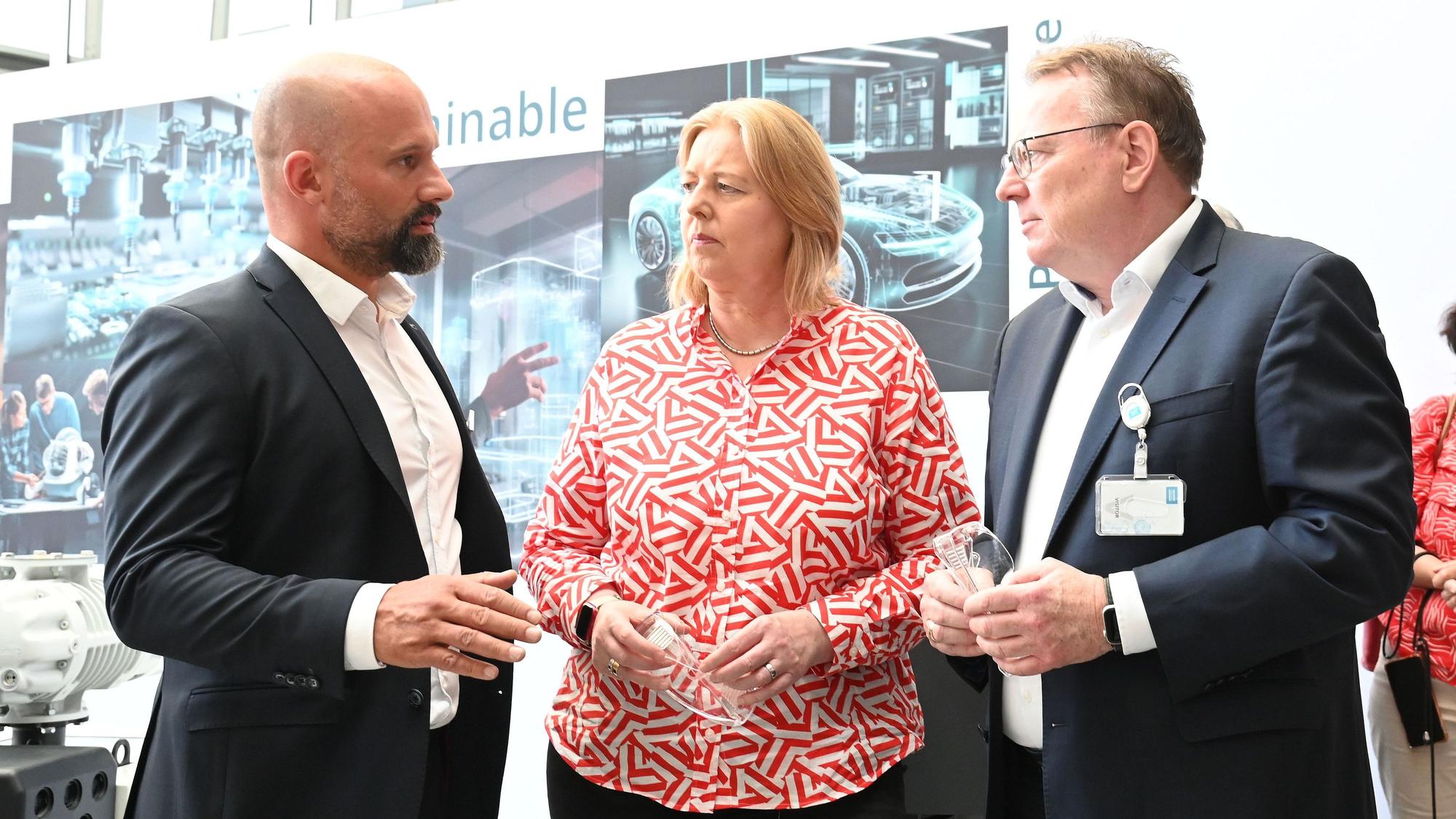 Der Kölner OB-Kandidat Torsten Burmester und Bundes-Arbeitsministerin Bärbel Bas (beide SPD) im Gespräch mit Mark Gabriel, dem Geschäftsführer der Leybold GmbH in Bayenthal.