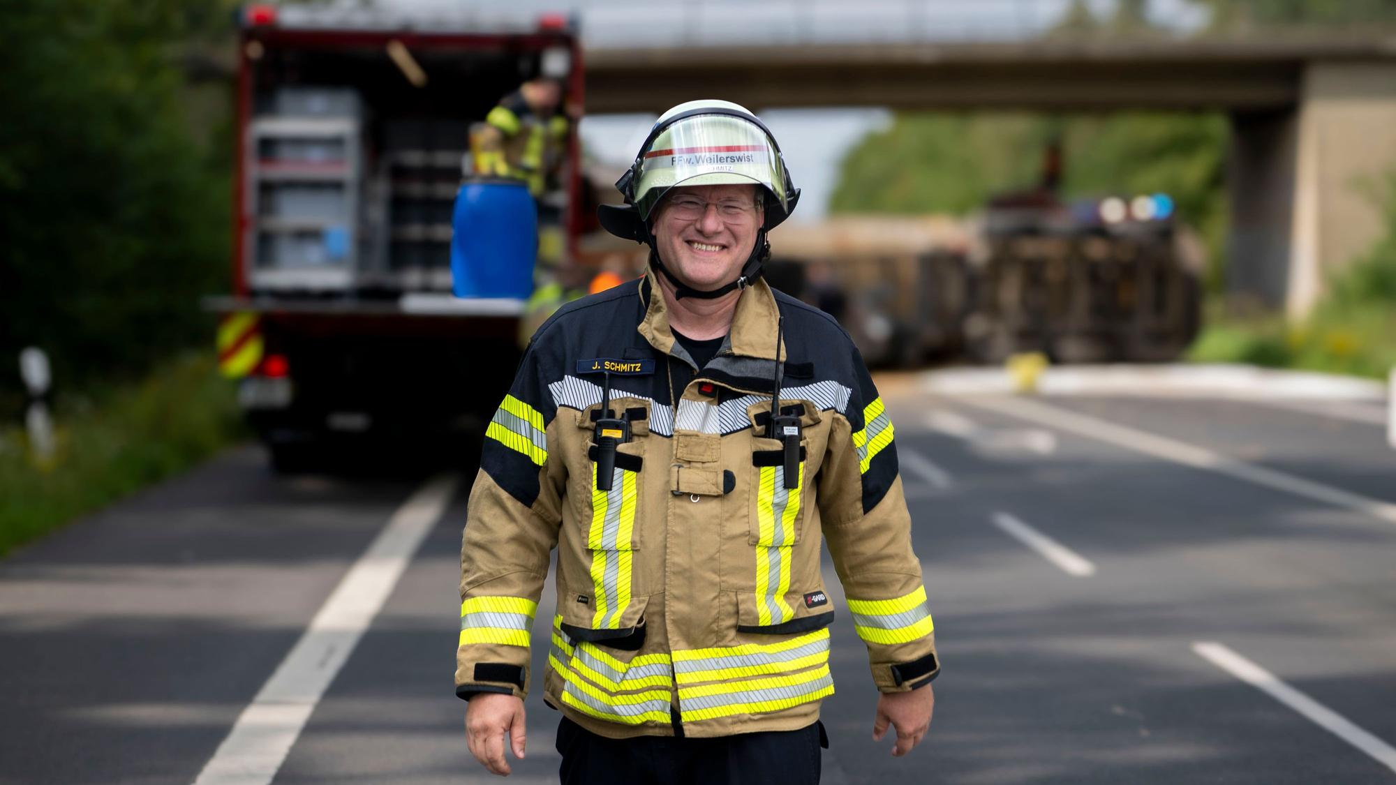 Das Bild zeigt Jürgen Schmitz in Feuerwehrmontur auf einer Straße.