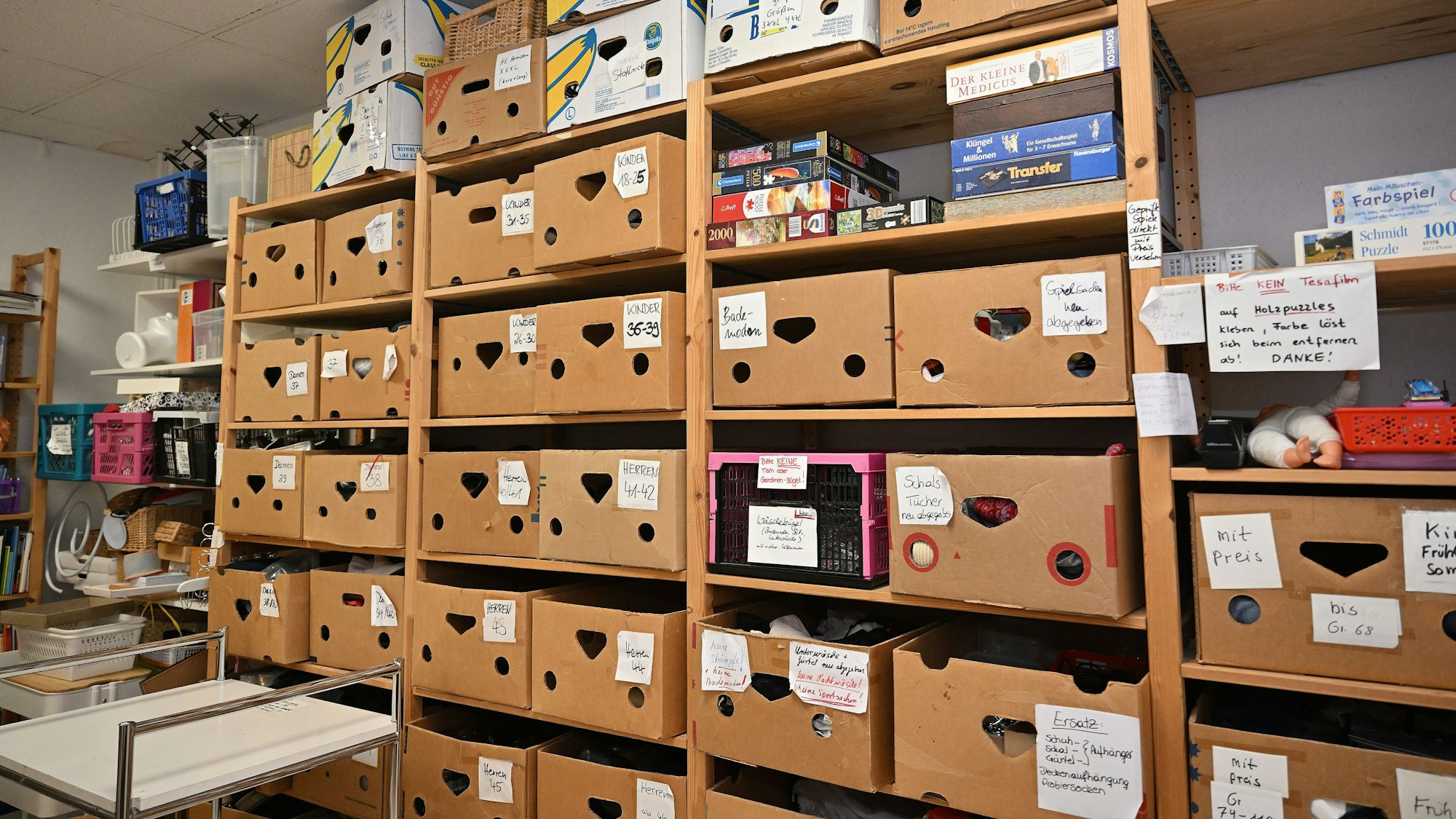 Ein Regal voller Kisten, in denen Kleidung und weitere Waren untergebracht werden.