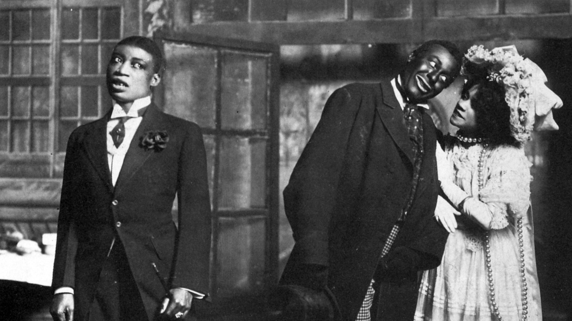Bert Williams (l) mit seinem Bühnenpartner George Walker (m) und der Tänzerin Aida Overton Walker, um 1905.