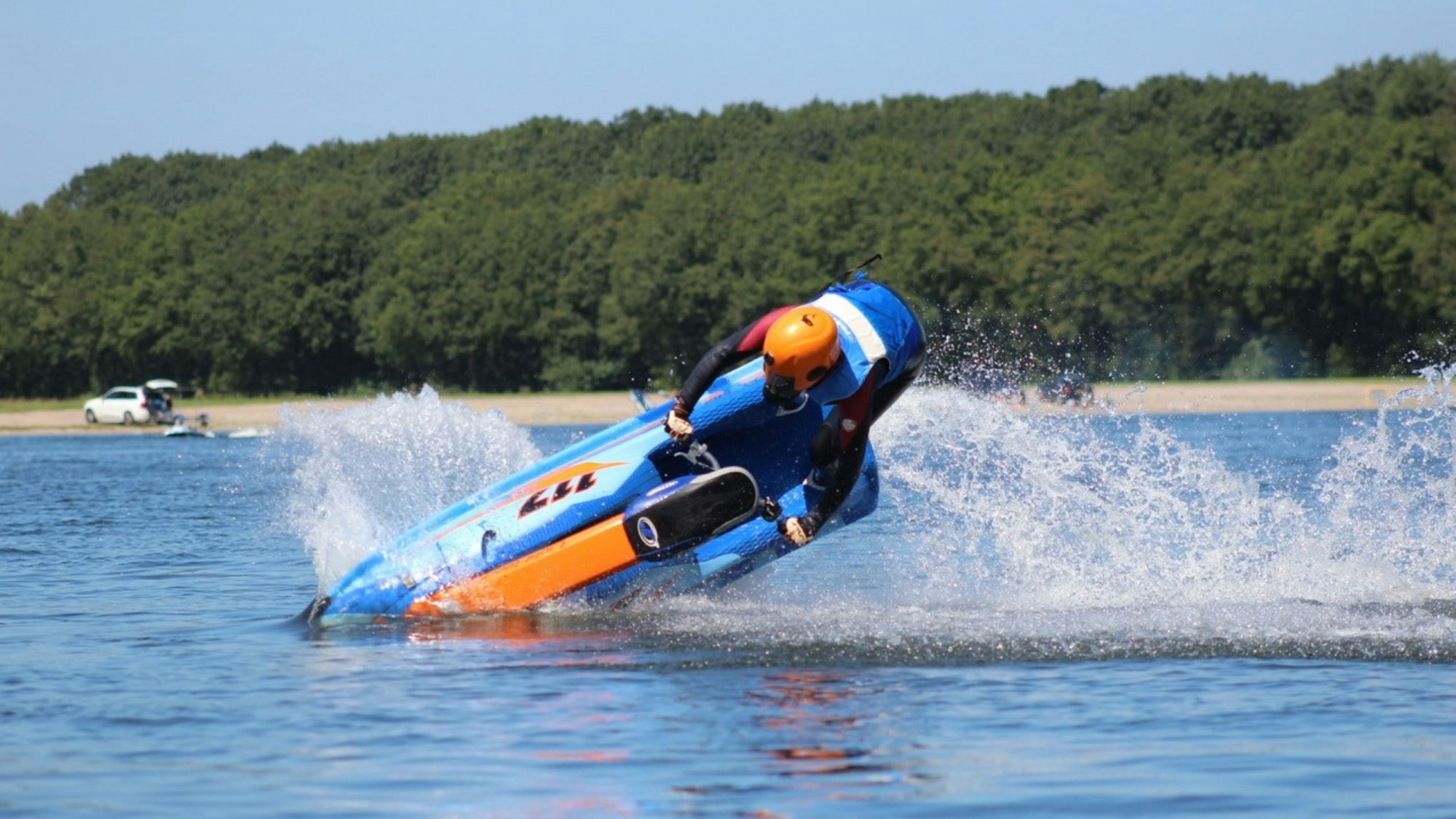 Eine junge Frau macht einen Trick auf ihrem Jet-Ski auf dem See.