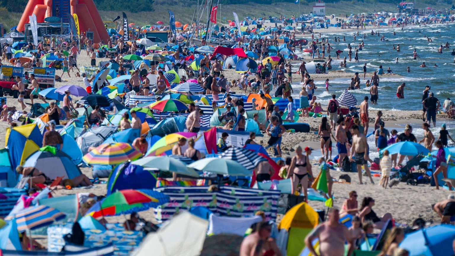 dpatopbilder - 13.08.2025, Mecklenburg-Vorpommern, Zinnowitz: Touristen halten sich bei Sonne und hochsommerlichen Temperaturen im Ostseebad am Strand und im Wasser auf. Foto: Stefan Sauer/dpa +++ dpa-Bildfunk +++