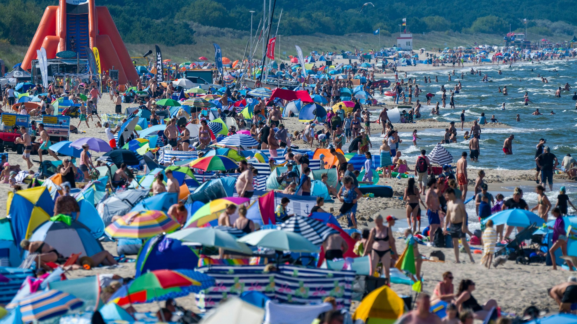 dpatopbilder - 13.08.2025, Mecklenburg-Vorpommern, Zinnowitz: Touristen halten sich bei Sonne und hochsommerlichen Temperaturen im Ostseebad am Strand und im Wasser auf. Foto: Stefan Sauer/dpa +++ dpa-Bildfunk +++