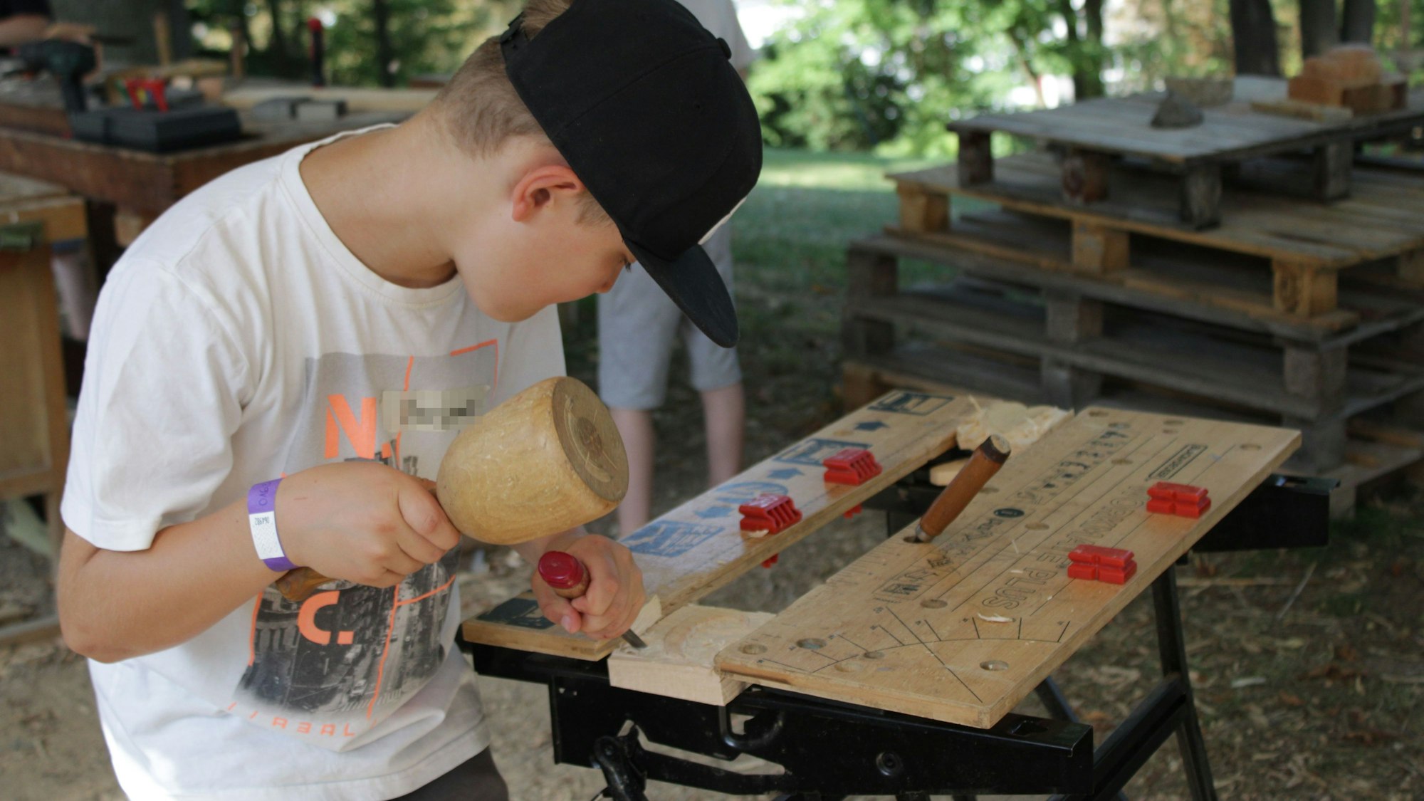Dirk Müller leitet die Kinder in der Bearbeitung von Holz an.