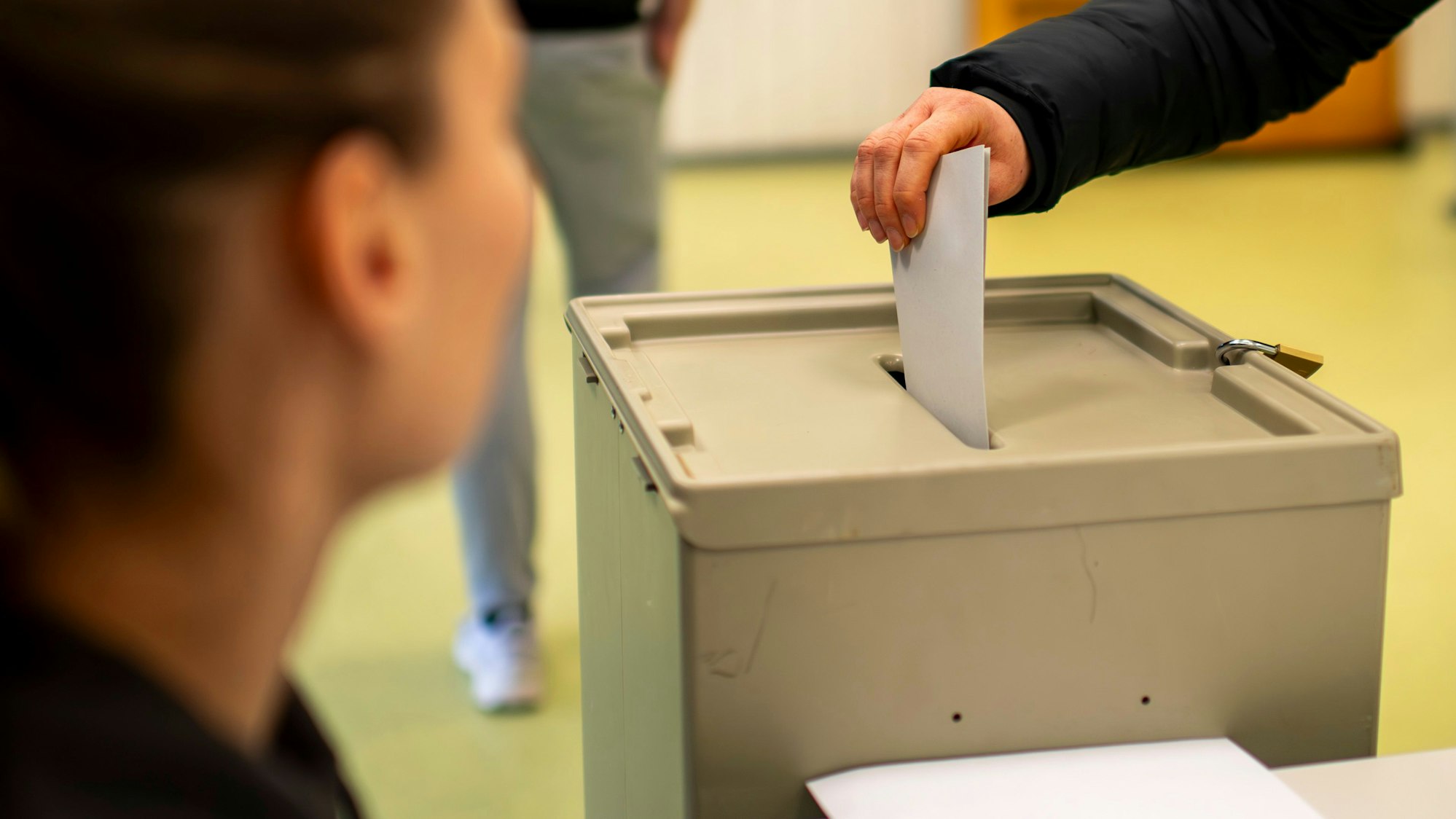 Das Bild zeigt eine Bürgerin, die bei der Bundestagswahl ihren Stimmzettel in die Urne wirft.