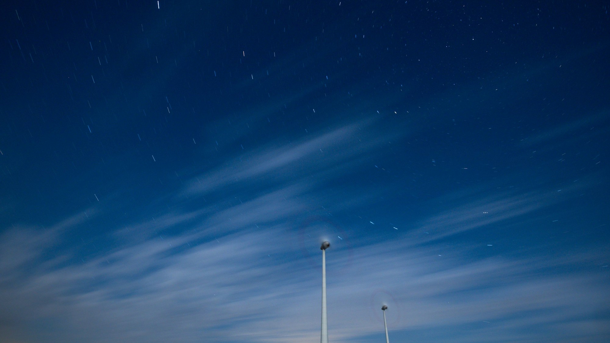 Wolken ziehen am Nachthimmel über einem Windpark und verhindern die Beobachtung des Sternschnuppen-Stroms der Perseiden.