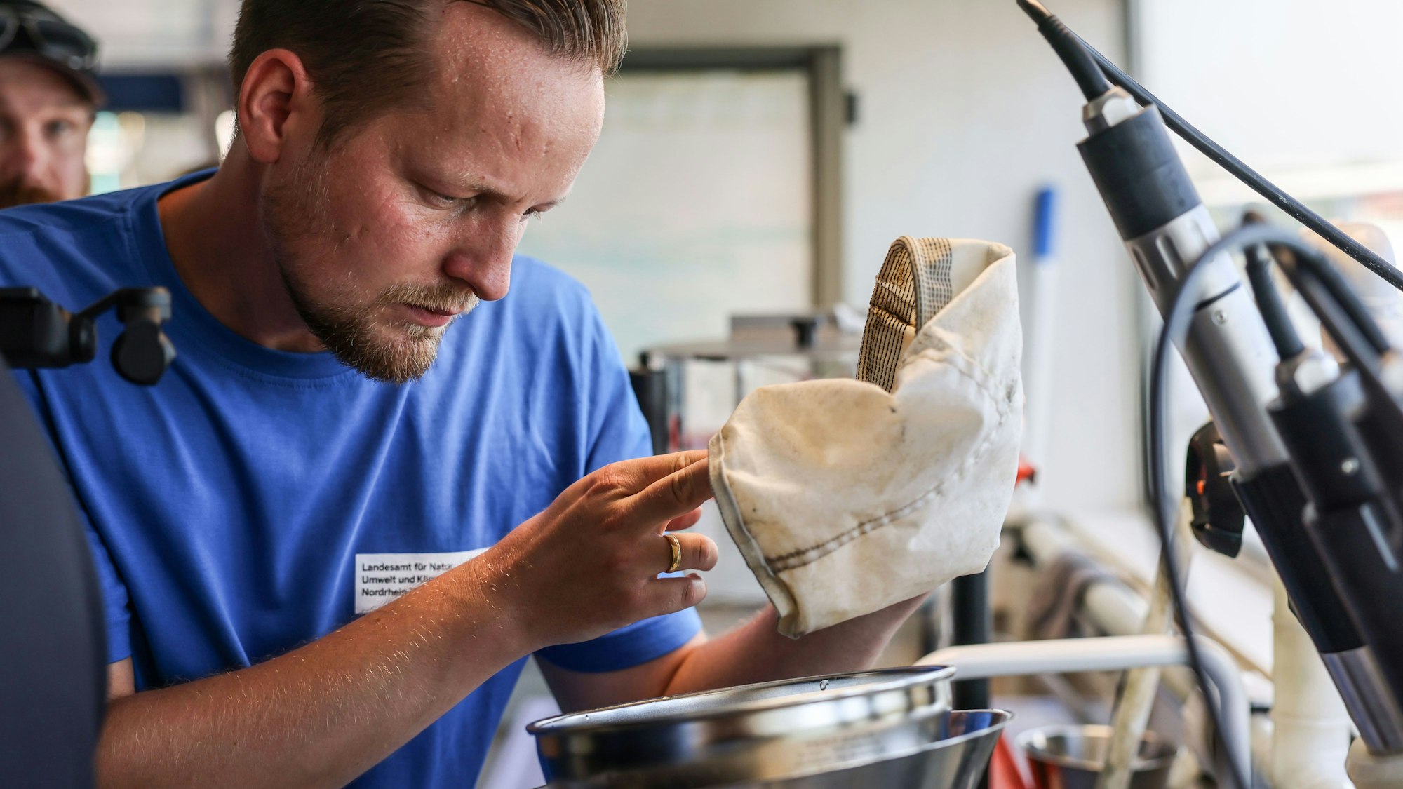 Ein Mitarbeiter des Landesamtes für Natur, Umwelt und Klima (LANUK), begutachtet auf dem Laborschiff Max Prüss eine Wasserprobe. Foto: Oliver Berg/dpa