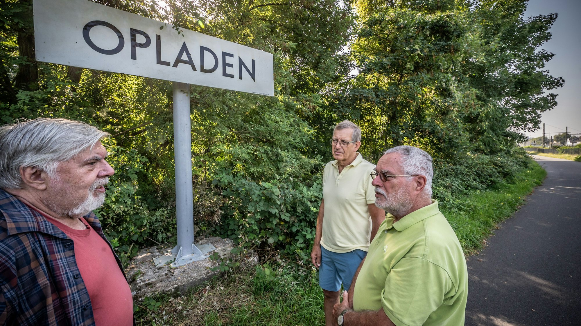 Stifter Kurt Kais und Peter Willwacher und Jürgen Wasse (v.l.) vom Verein Balkantrasse stehen vor dem alten Opladener Stationsschild. Bild: Ralf Krieger