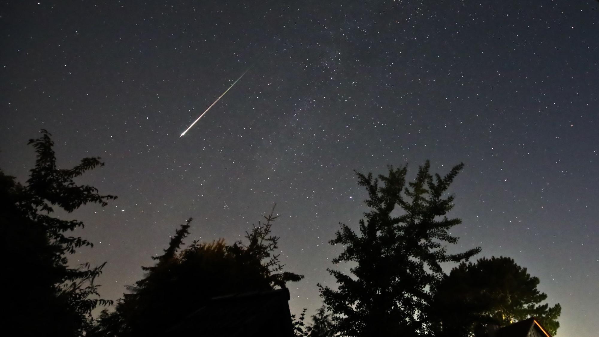 Ein Perseidenmeteor zieht 2023 über den Himmel. Jedes Jahr im August kreuzt die Erde die Bahn eines Kometen.