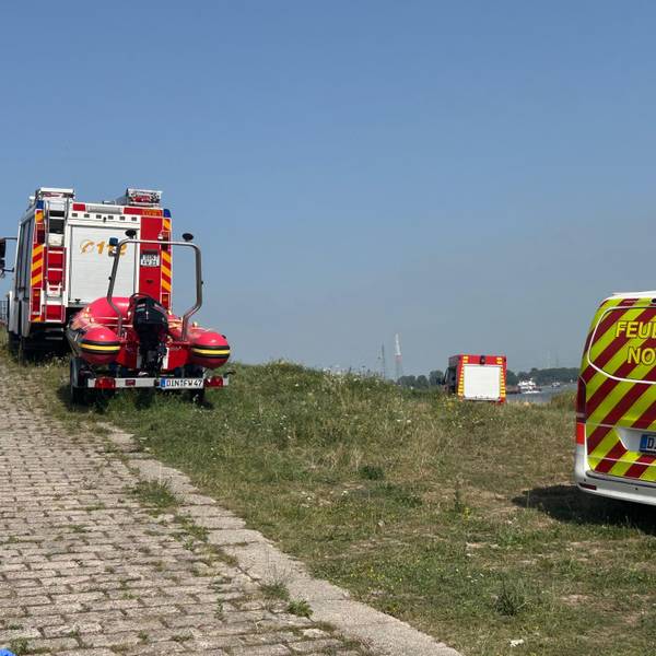 Einsatzfahrzeuge der Feuerwehr Dinslaken am Rhein in Voerde, nachdem Passanten eine Leiche im Wasser entdeckt hatten.