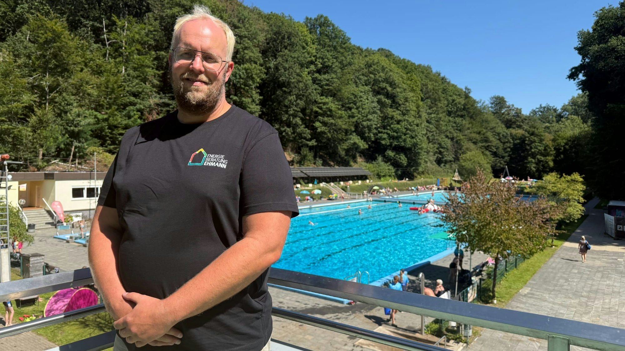 Schornsteinfeger André Ehmann vor dem Schwimmerbecken im Freibad.