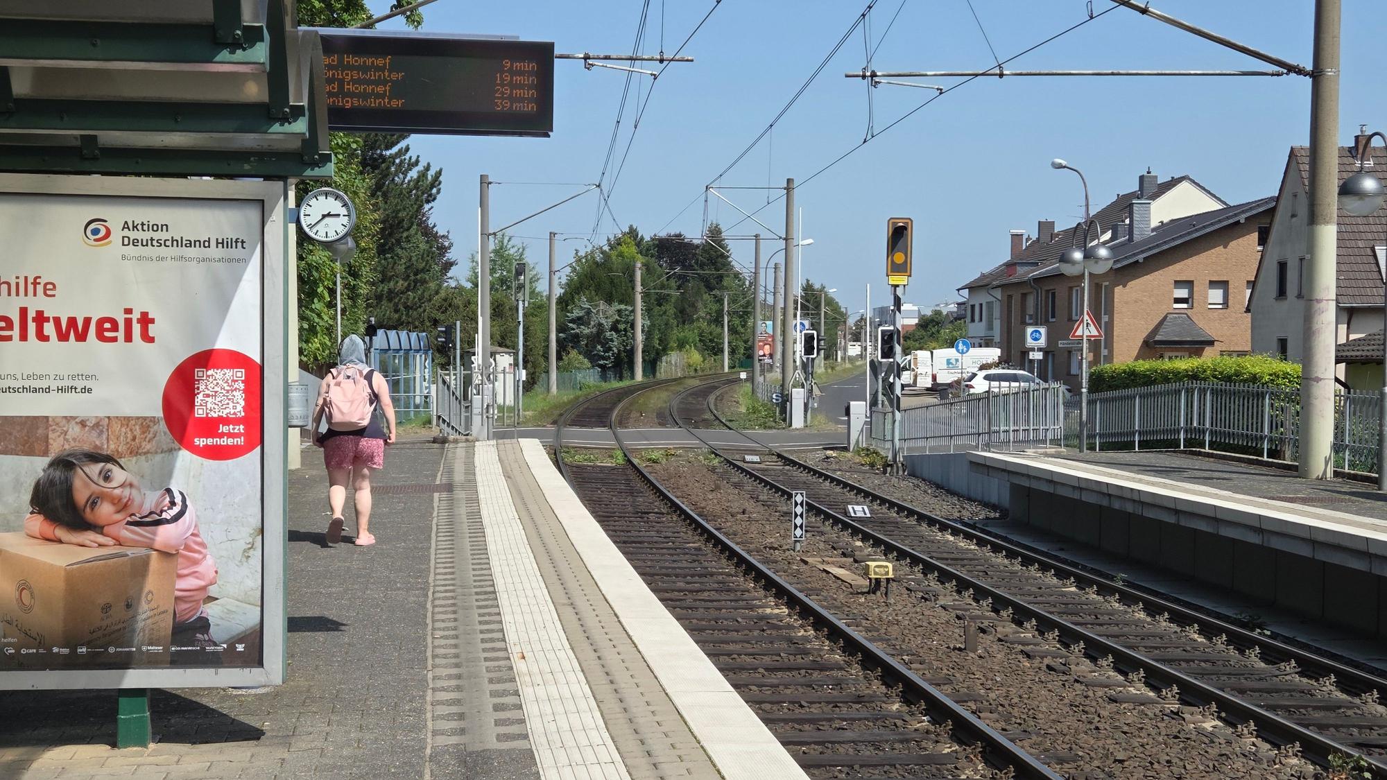 Wenig Schatten findet sich an der Haltestelle der 66 in Hangelar West. Eine Pendlerin schützt sich mit einem Tuch auf dem Kopf vor der knalligen Sonne.