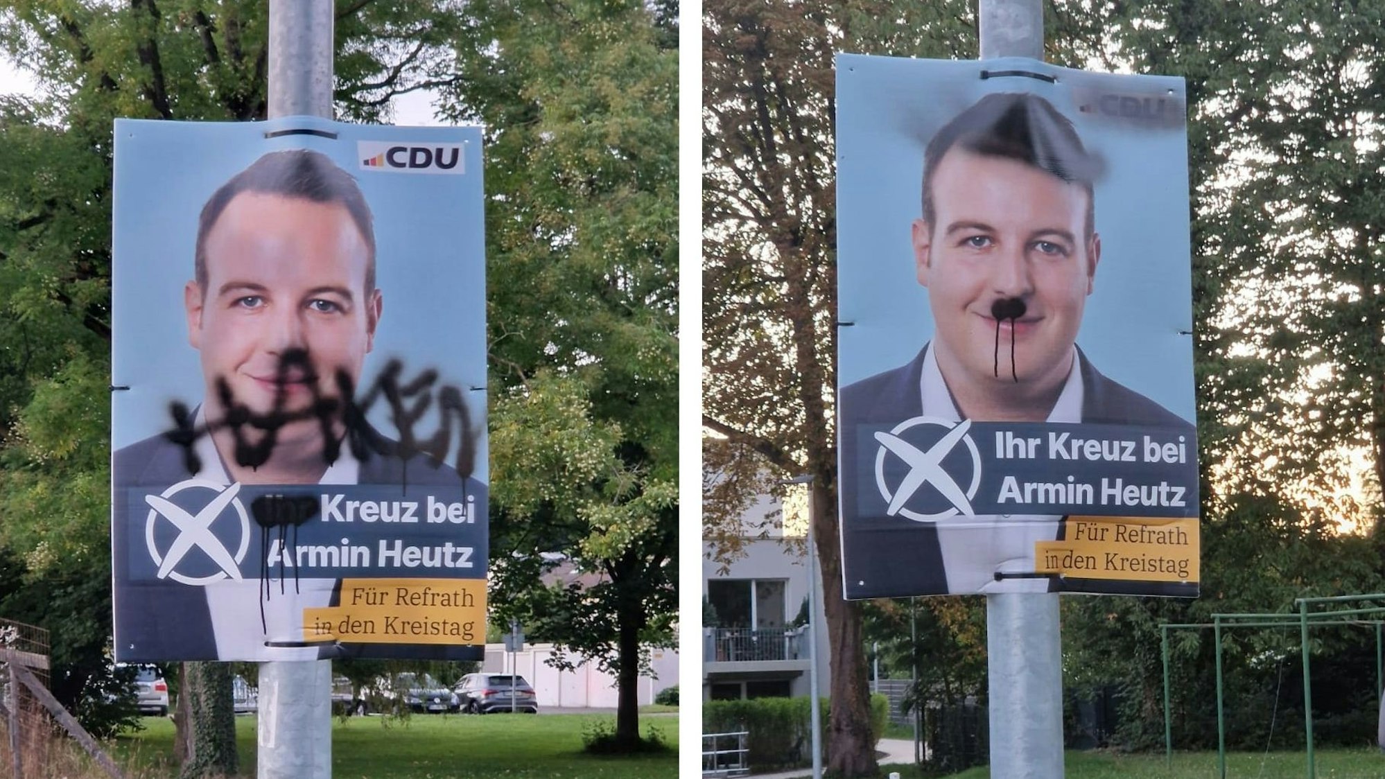 Zwei Plakate, die mit Farbe beschmiert worden sind, hängen an Laternenmasten in Bergisch Gladbach-Refrath.