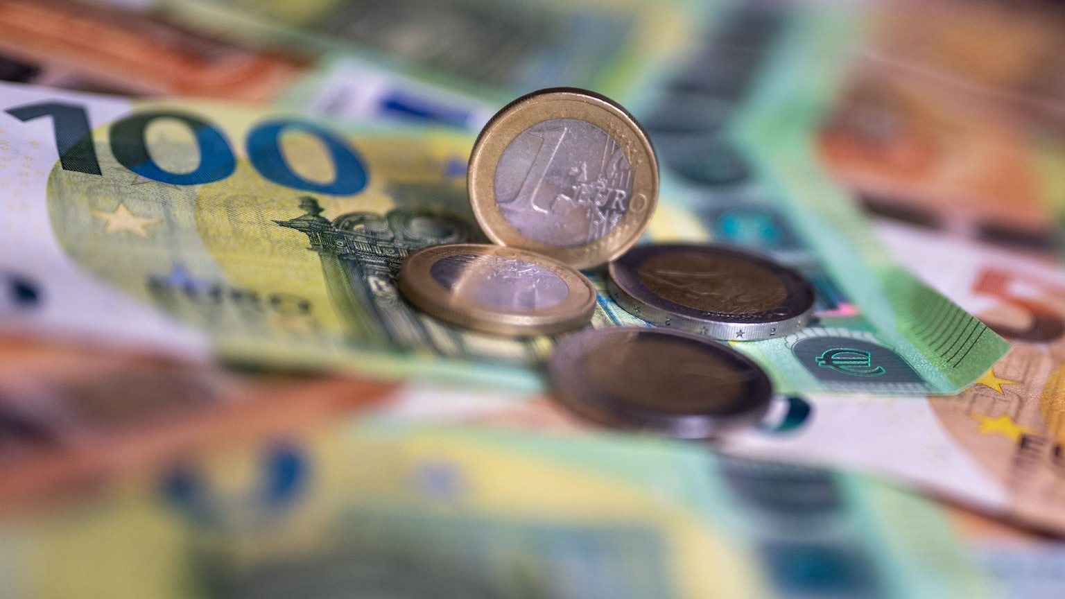 Geldscheine und Münzen liegen auf einem Tisch.