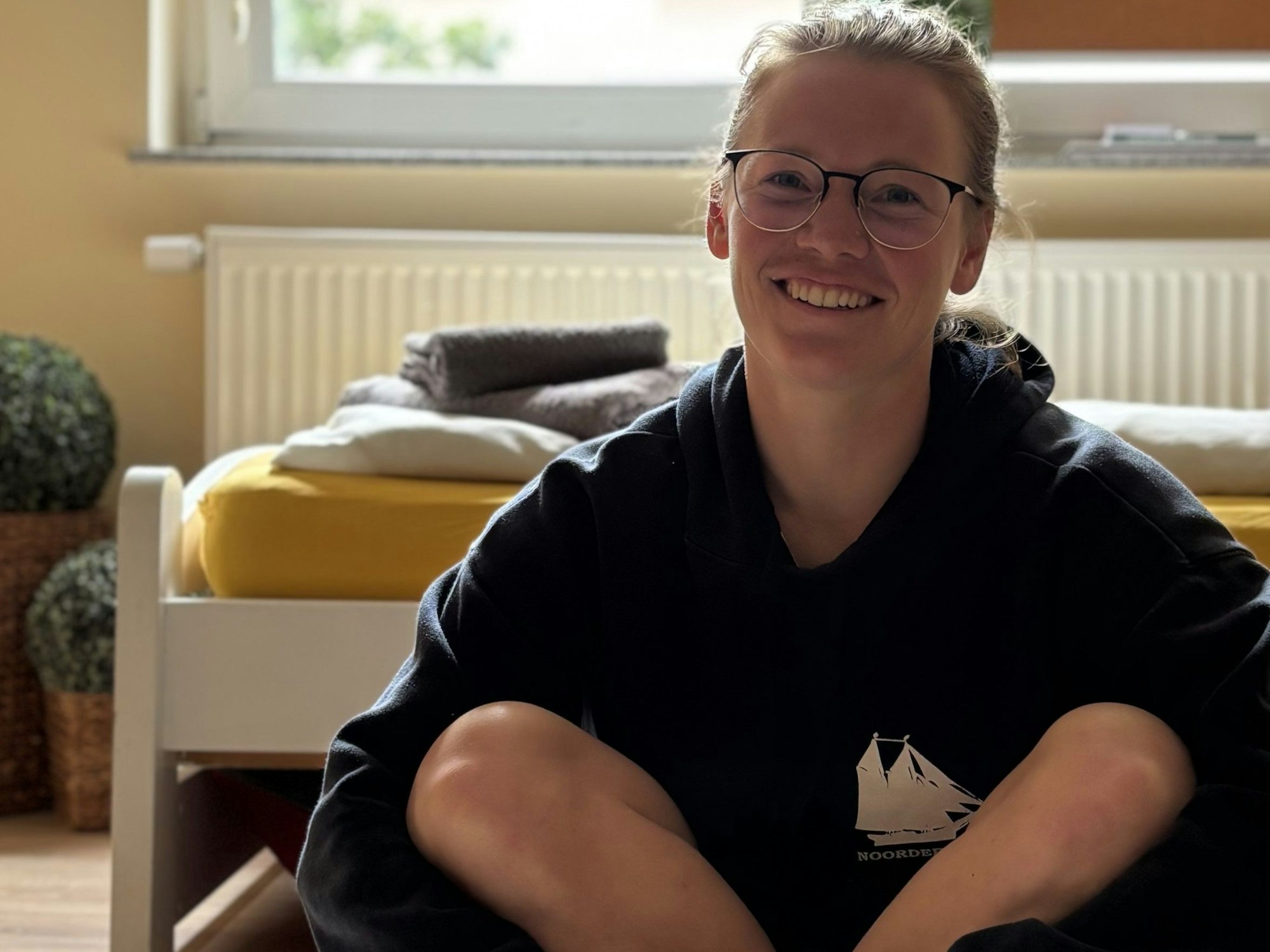 Annika Salveter sitzt in der Wohnung in Bremerhaven auf dem Teppich aus der Wolle von Kölner Schafen. Der geht mit in die Antarktis.