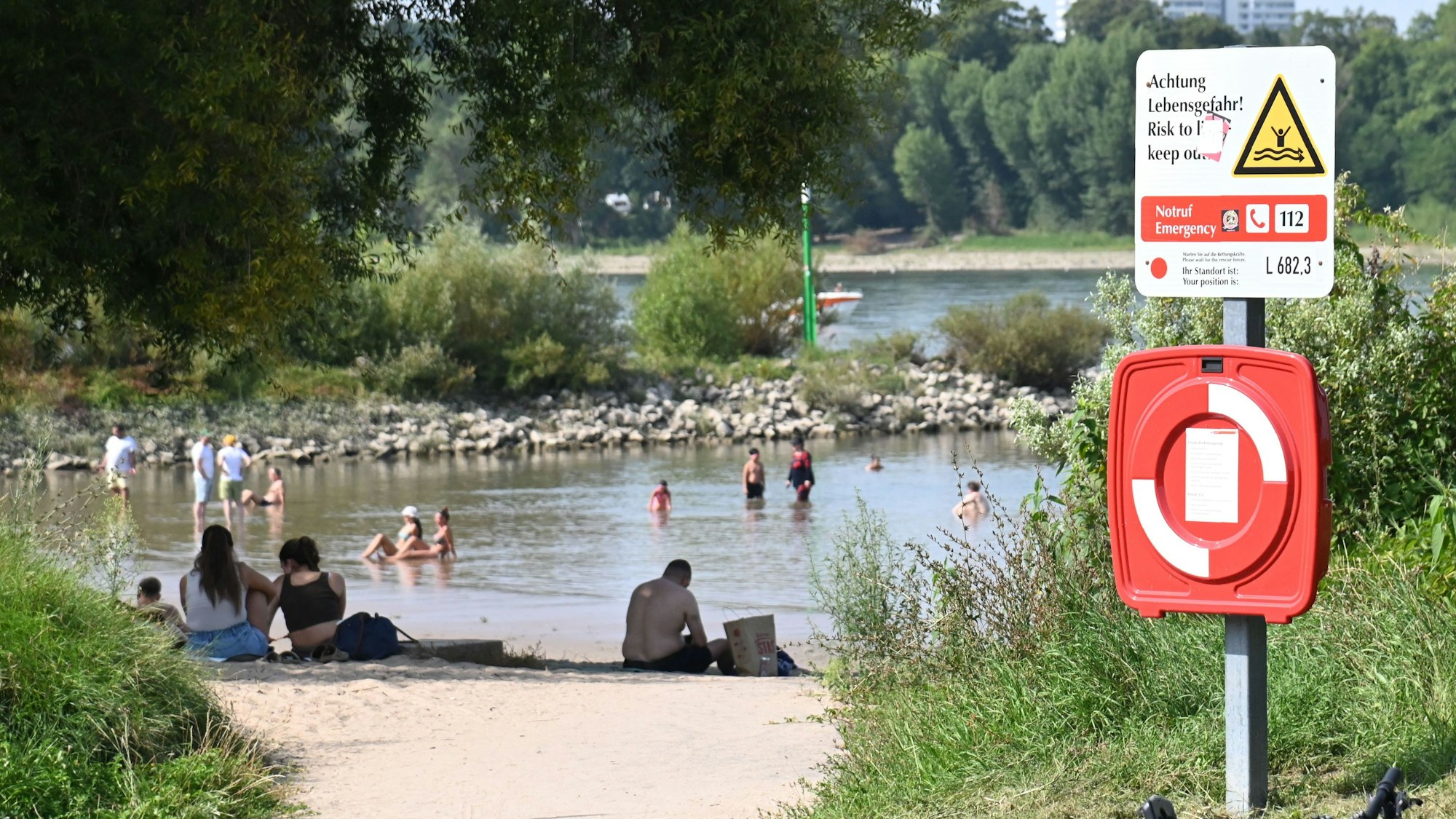 13.08.2025 Köln. Wetter, Feature: Sommer. Derzeit ist es heiß und sonnig. Auch an den Sandstränden des Rheins, der Rodenkirchener Riviera, suchen die Menschen Abkühlung im Wasser. Baden und Schwimmen im Rhein ist dort lebensgefährlich. Das Achtung Lebensgefahr-Schild. Foto: Alexander Schwaiger