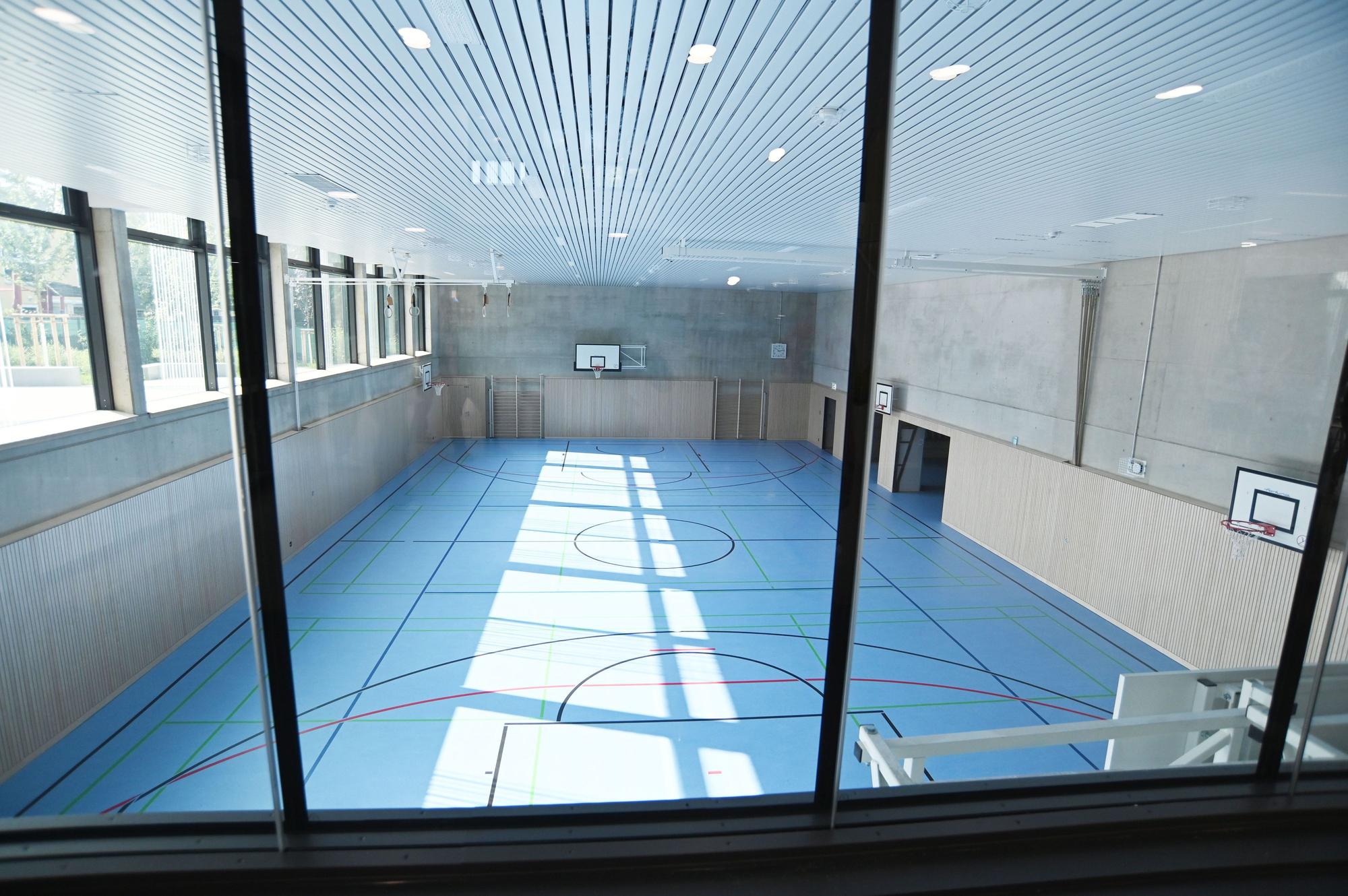 Die Turnhalle ist an das abschüssige Grundstück angepasst und teils unter der Erde.