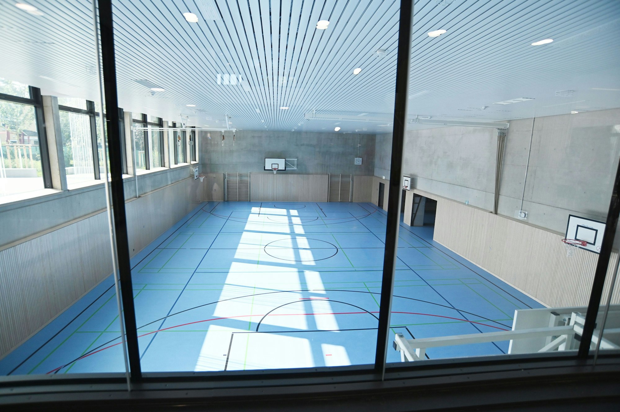 Die Turnhalle ist an das abschüssige Grundstück angepasst und teils unter der Erde.