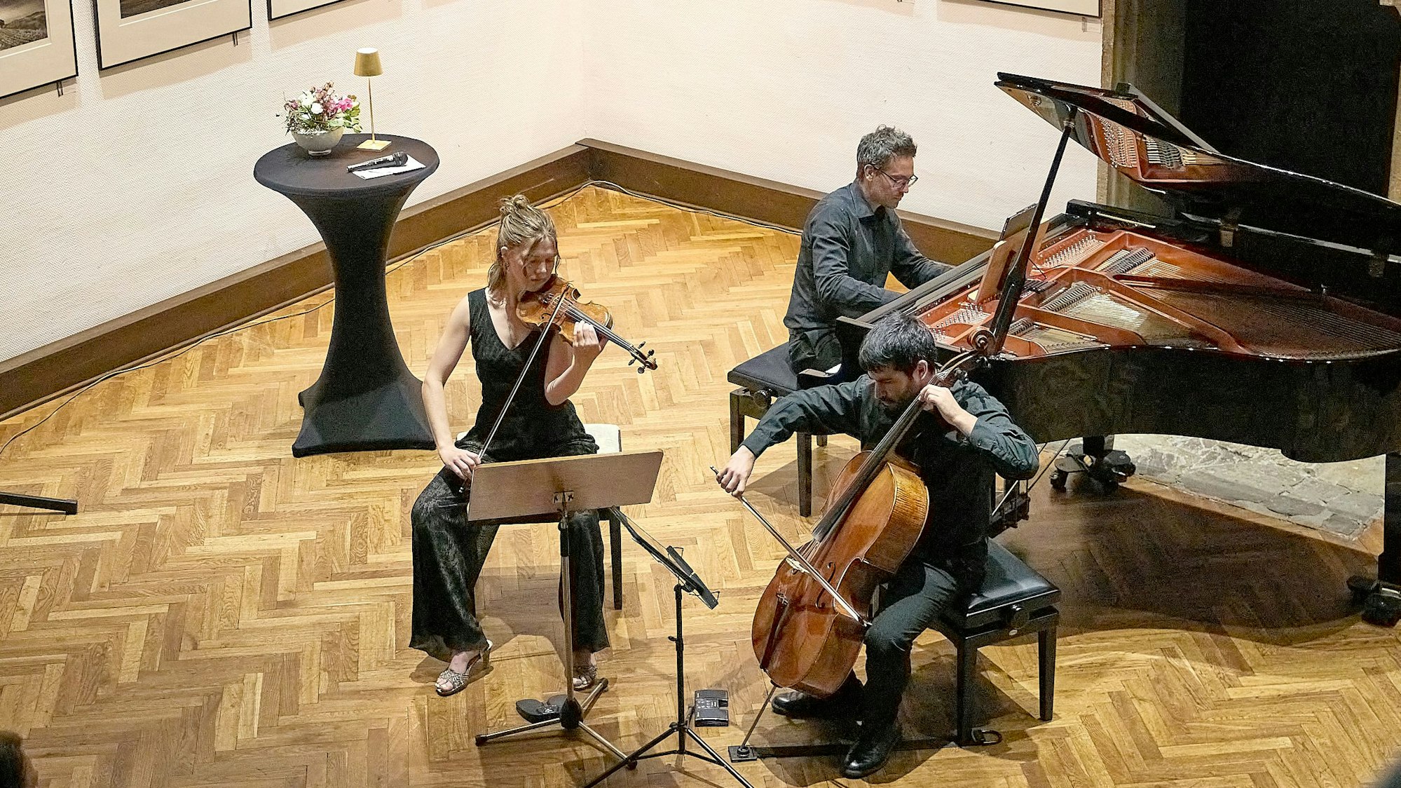 Zwei Musiker und eine Musikerin spielen auf ihren Instrumenten.