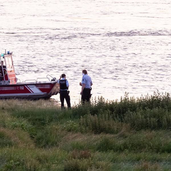 Einsatzkräfte der Polizei, Feuerwehr und DRLG arbeiten am Ufer des Rheins. (Archivfoto)