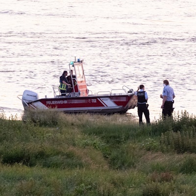 Einsatzkräfte der Polizei, Feuerwehr und DRLG arbeiten am Ufer des Rheins. (Archivfoto)