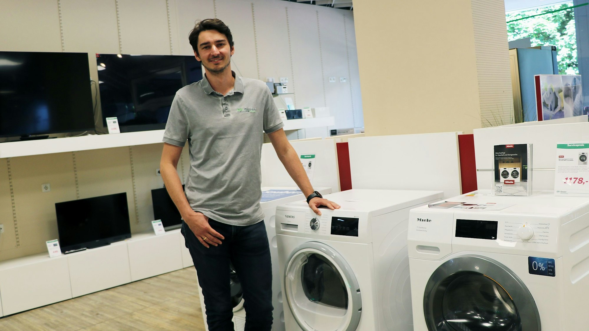 Das Foto zeigt einen jungen Mann in einem Geschäft für „Weiße Ware“.