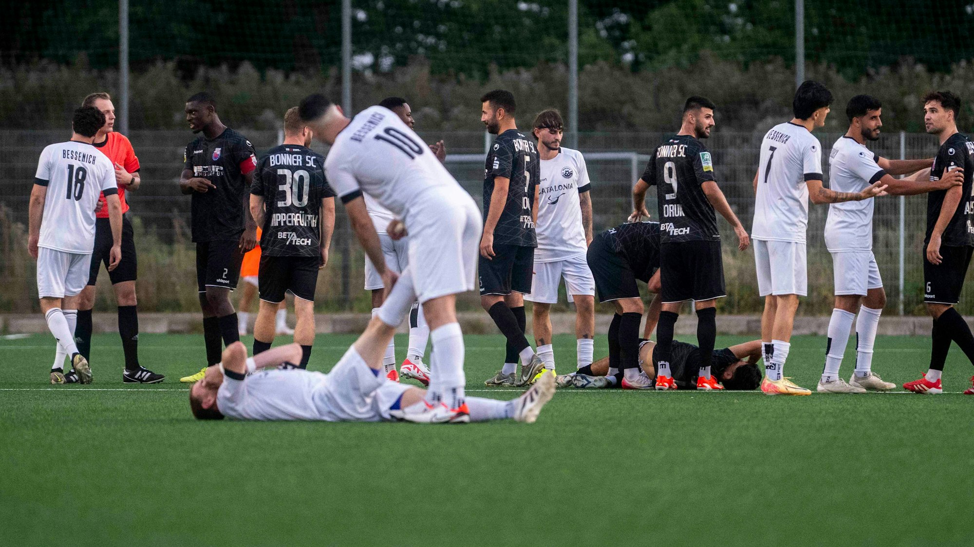 Das Bild zeigt, wie ein Krampf aus der Wade gedehnt wird. Im Hintergrund herrscht Rudelbildung.