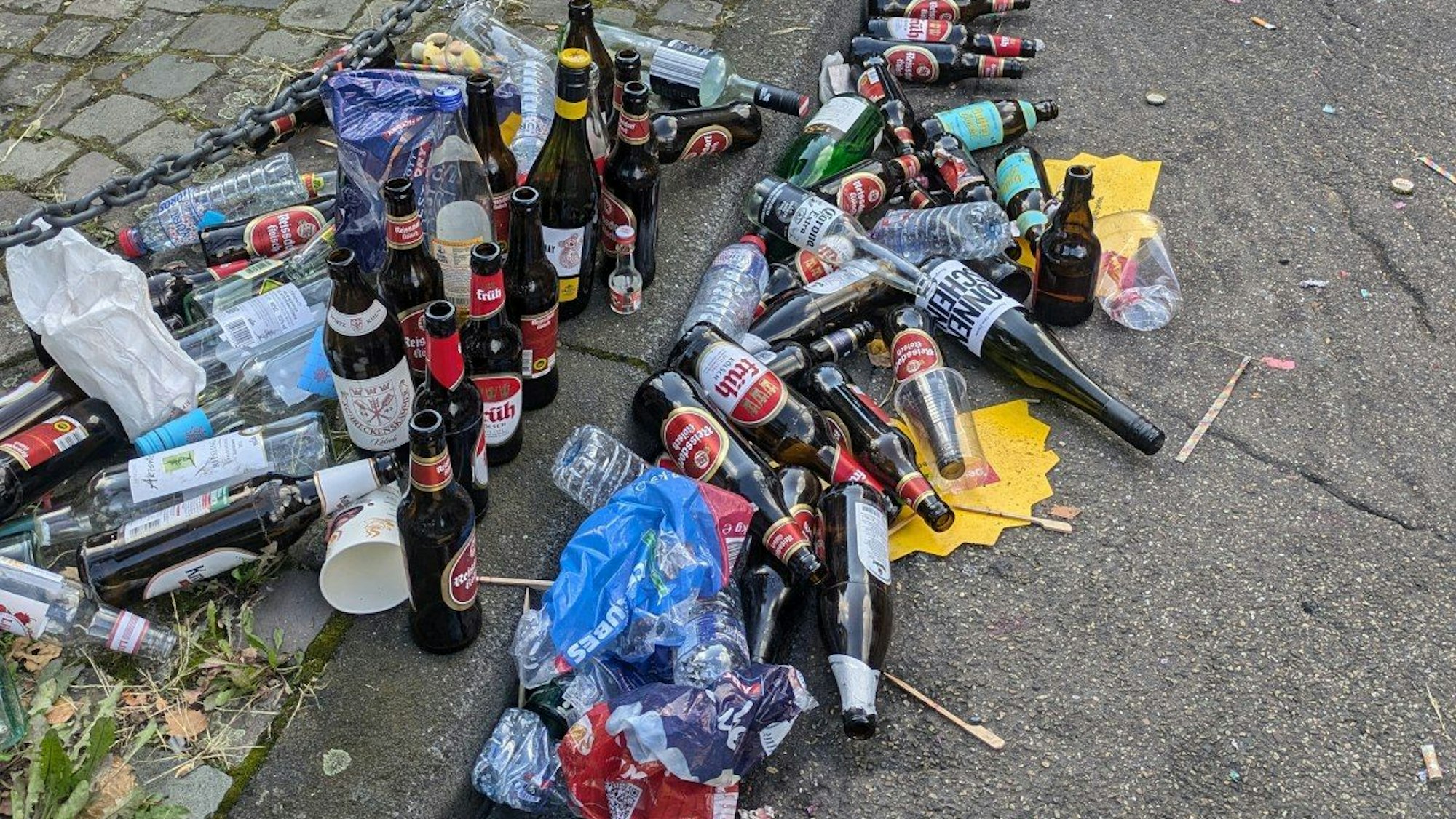 Glasflaschen und Müll liegen beim CSD am Kölner Neumarkt am Straßenrand.