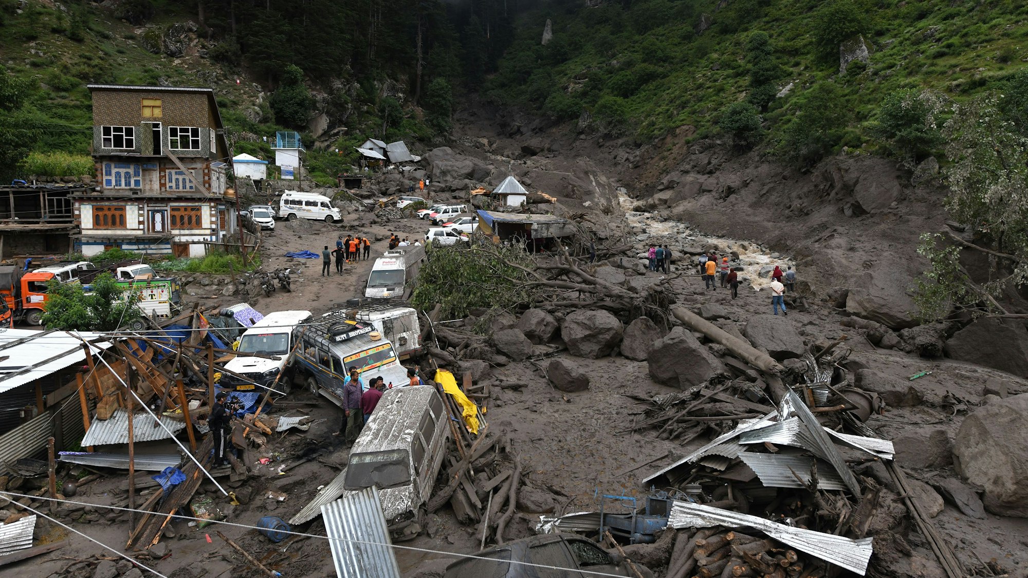 Rettungskräfte suchen zwischen Felsen und beschädigten Fahrzeugen nach Überlebenden und Opfern. Bei einer Sturzflut und Erdrutschen im indisch kontrollierten Teil von Kaschmir sind mehrere Menschen ums Leben gekommen.