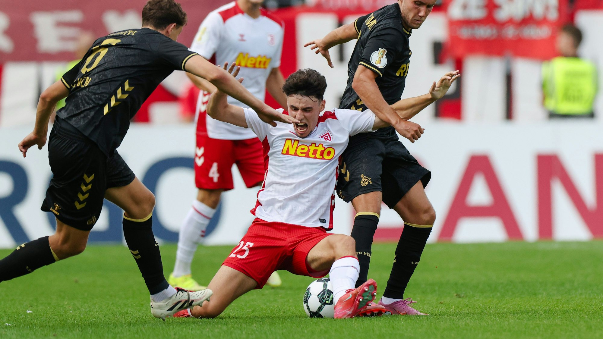 Eric Martel und Luca Waldschmidt im Duell mit Nicolas Oliveira von Jahn Regensburg beim Pokalspiel in Regensburg.
