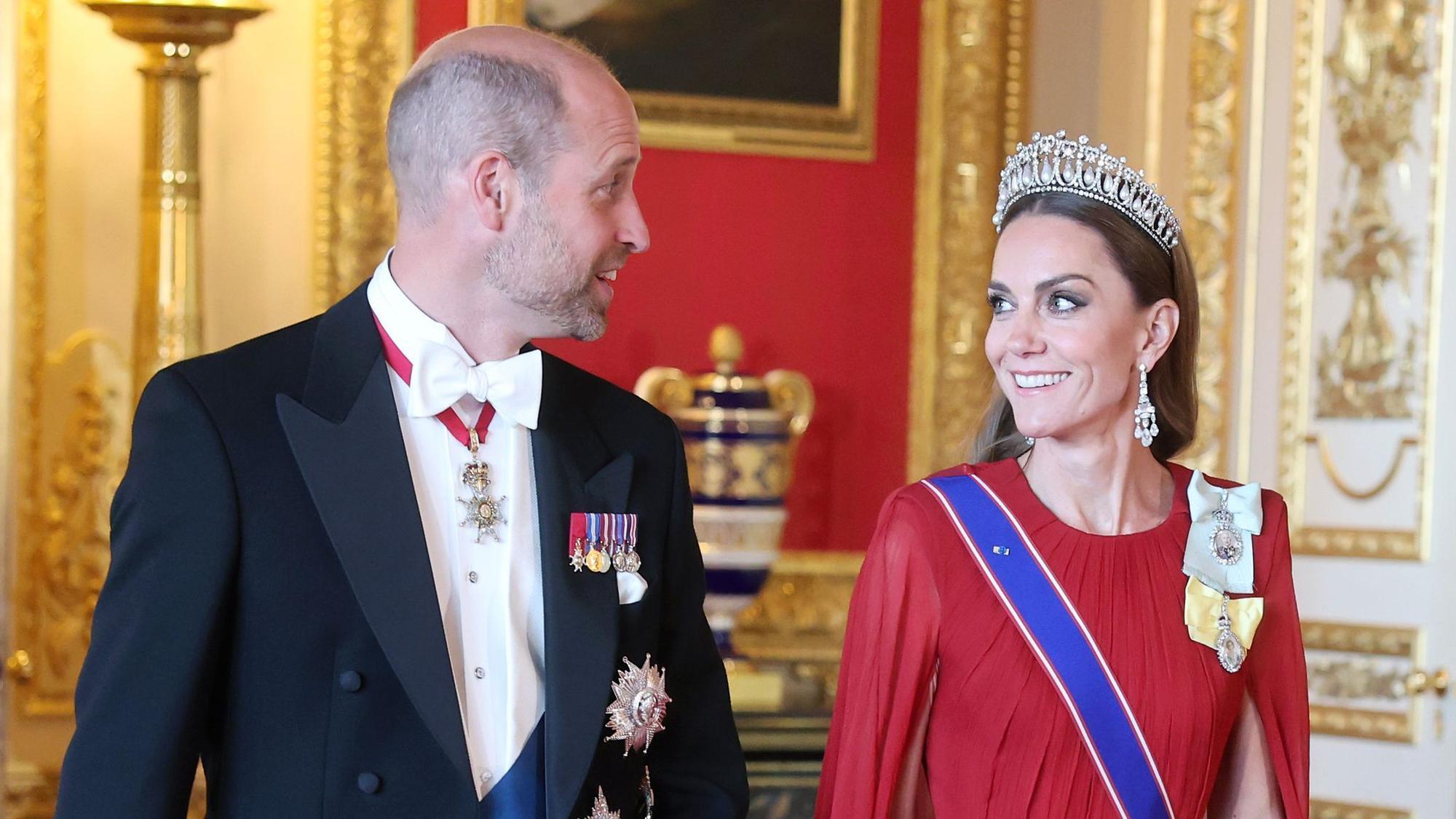 Prinz William und Kate gehen lachend nebeneinander.