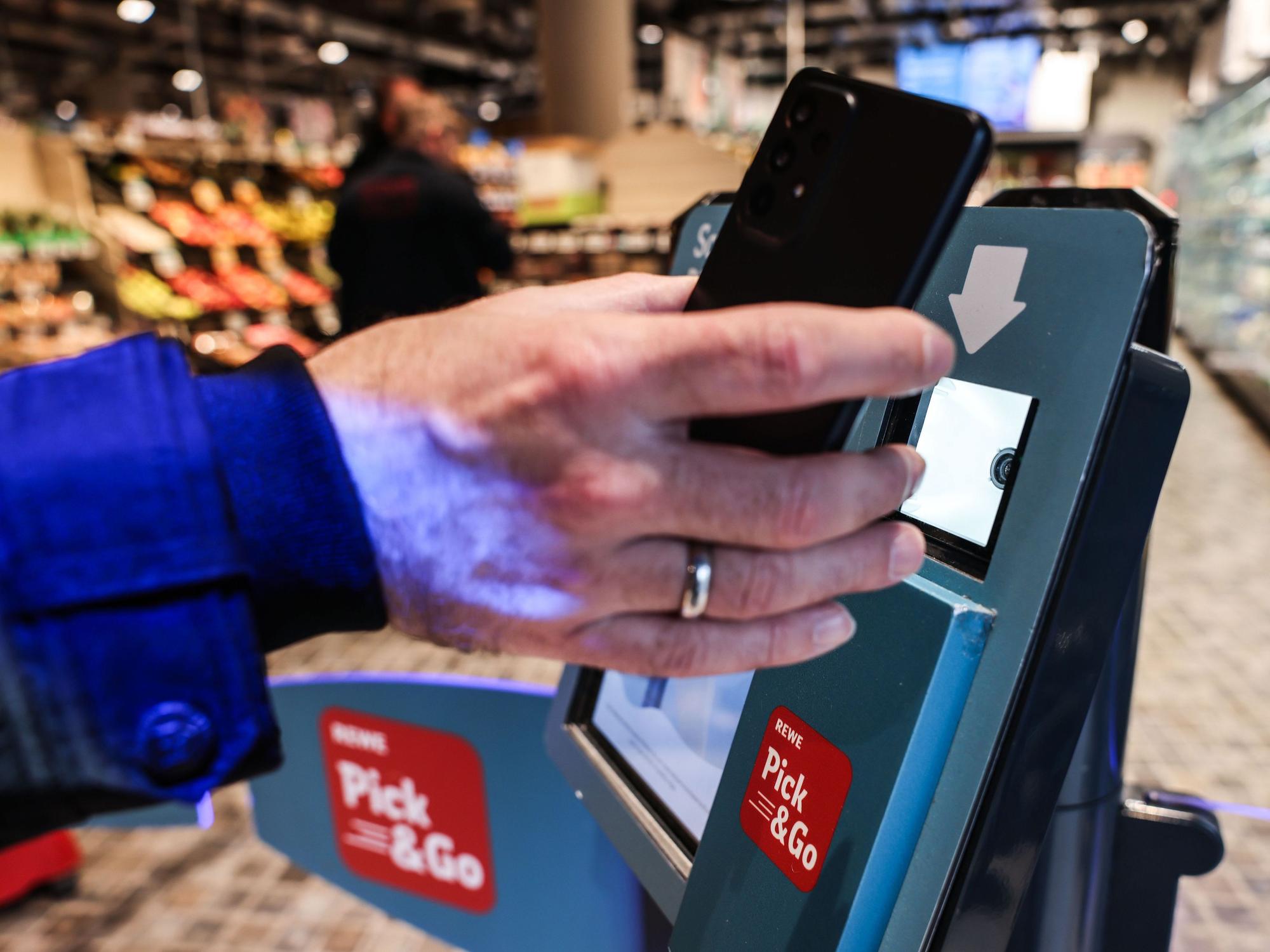Ein Kunde registriert sich am Eingang eines Rewe Pick & Go Supermarkts. Digital und teils ohne Personal - der Einkauf im Supermarkt ist im Umbruch.