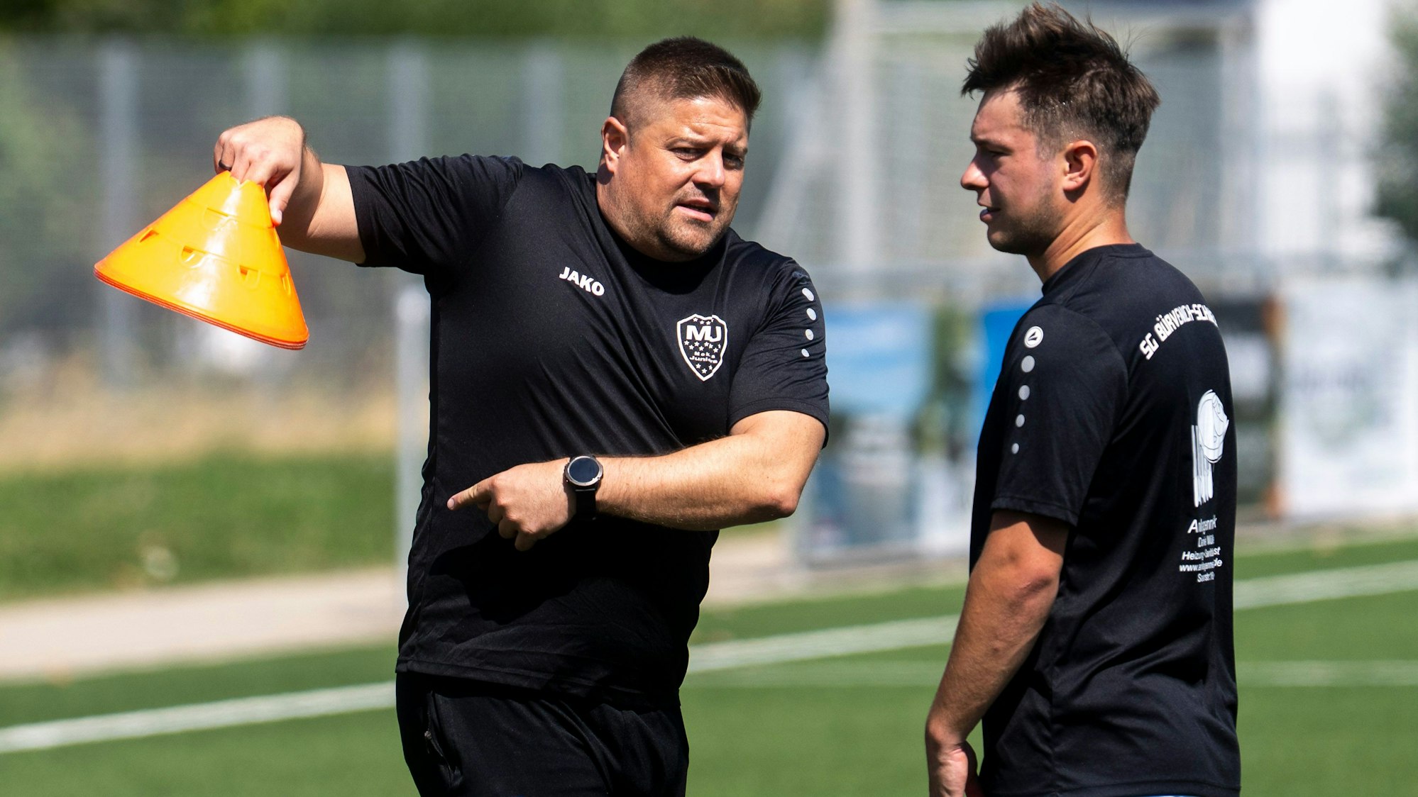 Das Bild zeigt Trainer Sascha Hillger im Gespräch mit einem Spieler.