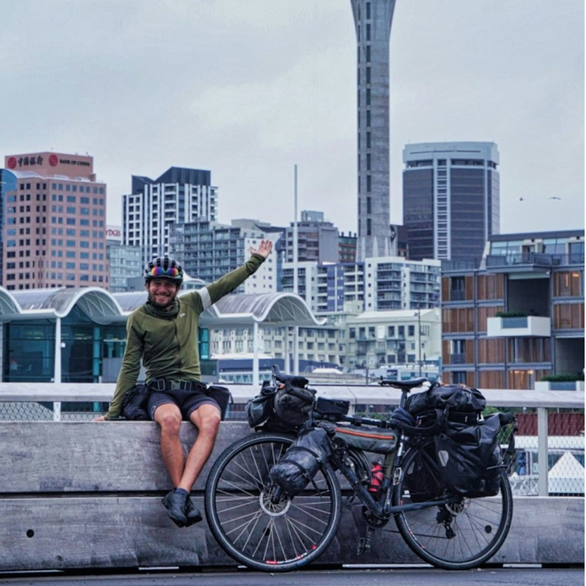 Florian Berg mit seinem Rad vor der Skyline einer Stadt.