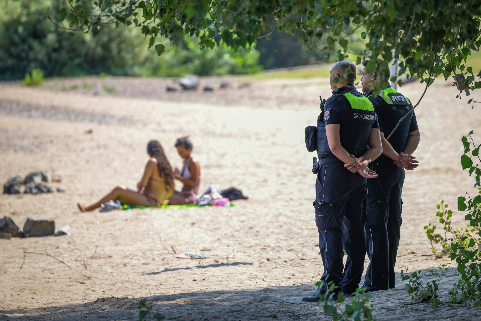 Mitarbeiter vom Ordnungsamt der Stadt Düsseldorf sind am sogenannten Paradiesstrand im Einsatz. Sie überwachen das Badeverbot im Rhein.